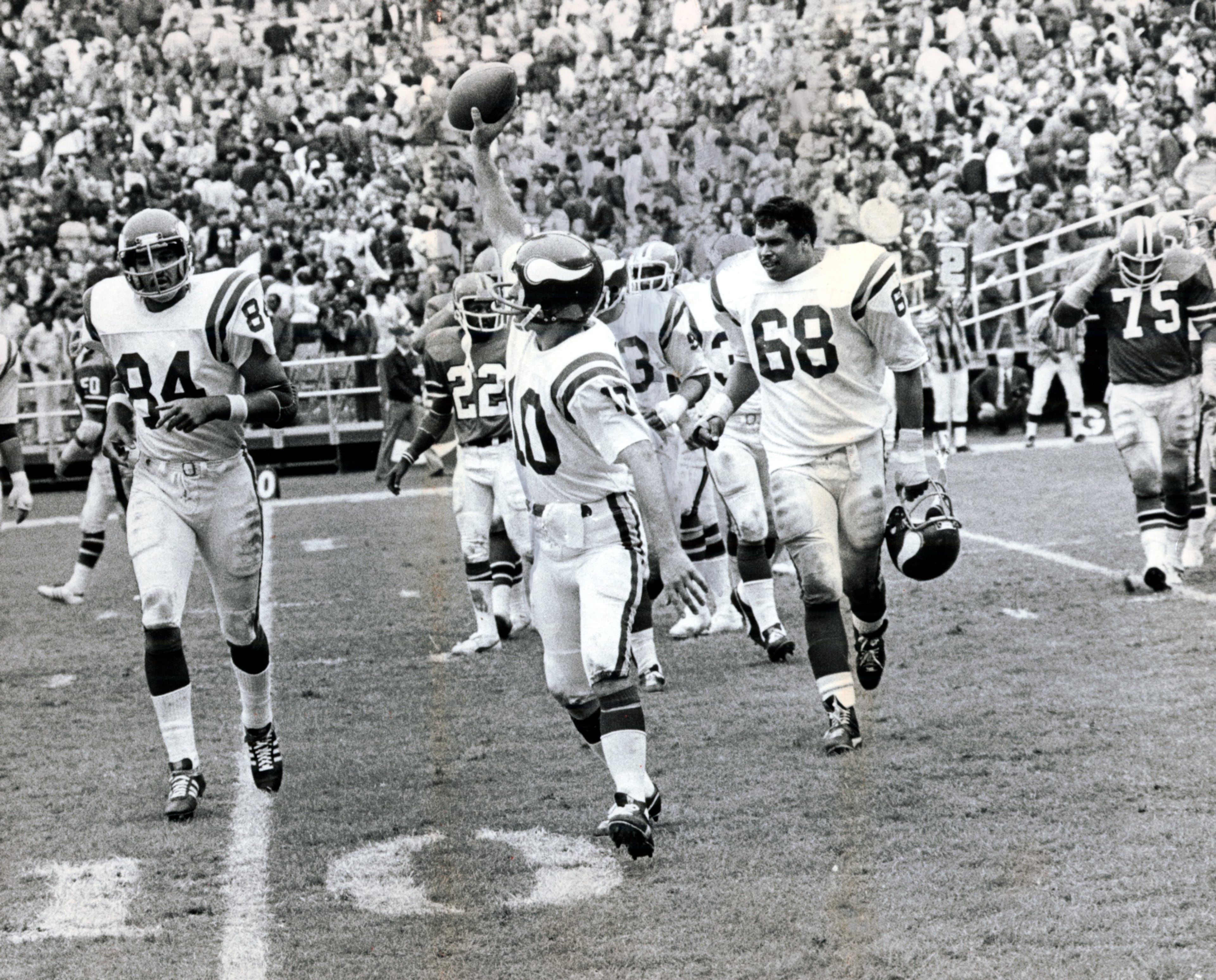 Vikings quarterback Fran Tarkenton walks off the field with the game ball after a game against the Falcons in 1977. (Charles Pugh/AJC staff)