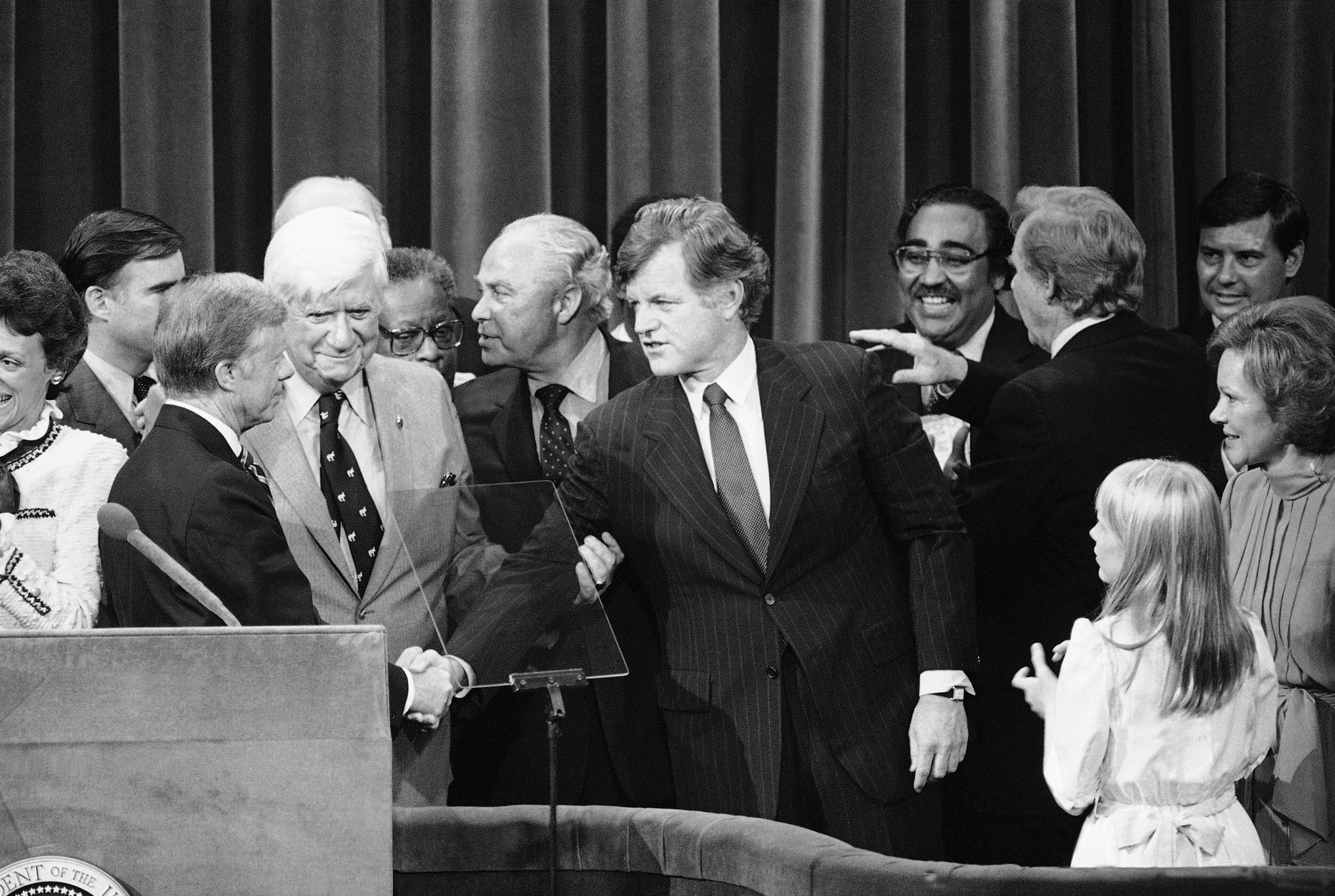 President Jimmy Carter shakes hands with Sen. Edward Kennedy on the podium at the Democratic National Convention in New York's Madison Square Garden, Aug. 15, 1980. The two had vied for the Democratic presidential nomination. Convention Chairman Tip O'Neill is second from left and Robert Strauss, the president's campaign manager, is second from right. Smiling over Kennedy's shoulder is Rep. Charles Rangel of New York. At far right is first lady Rosalynn Carter with daughter Amy beside her. (AP file)