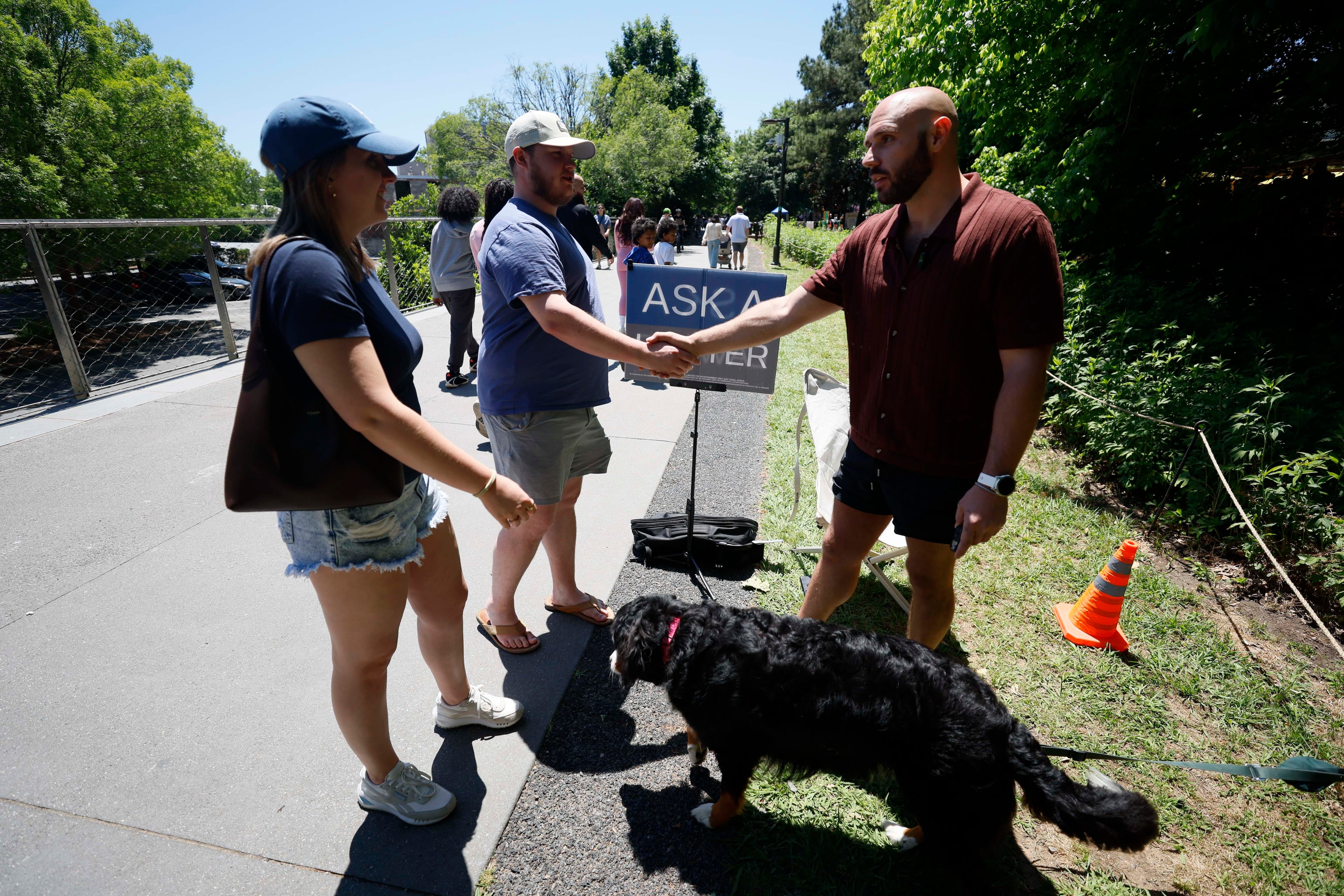 Marietta couple Joey Kostigen and Katie Dennard stop along the Beltline to speak with attorney Cody Randall after seeing his content on TikTok. (Miguel Martinez/AJC)