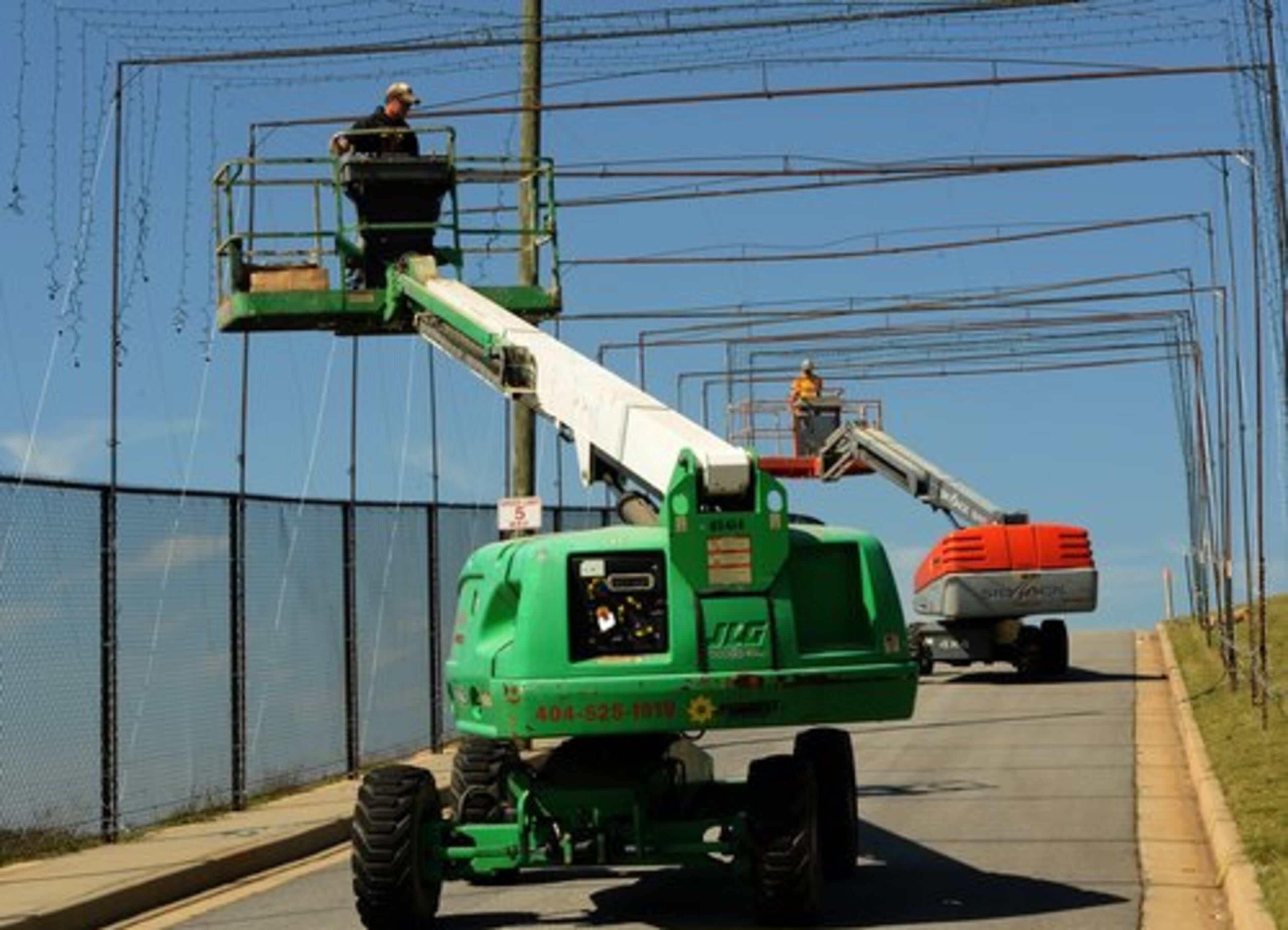 Workers hang lights to form a tunnel.