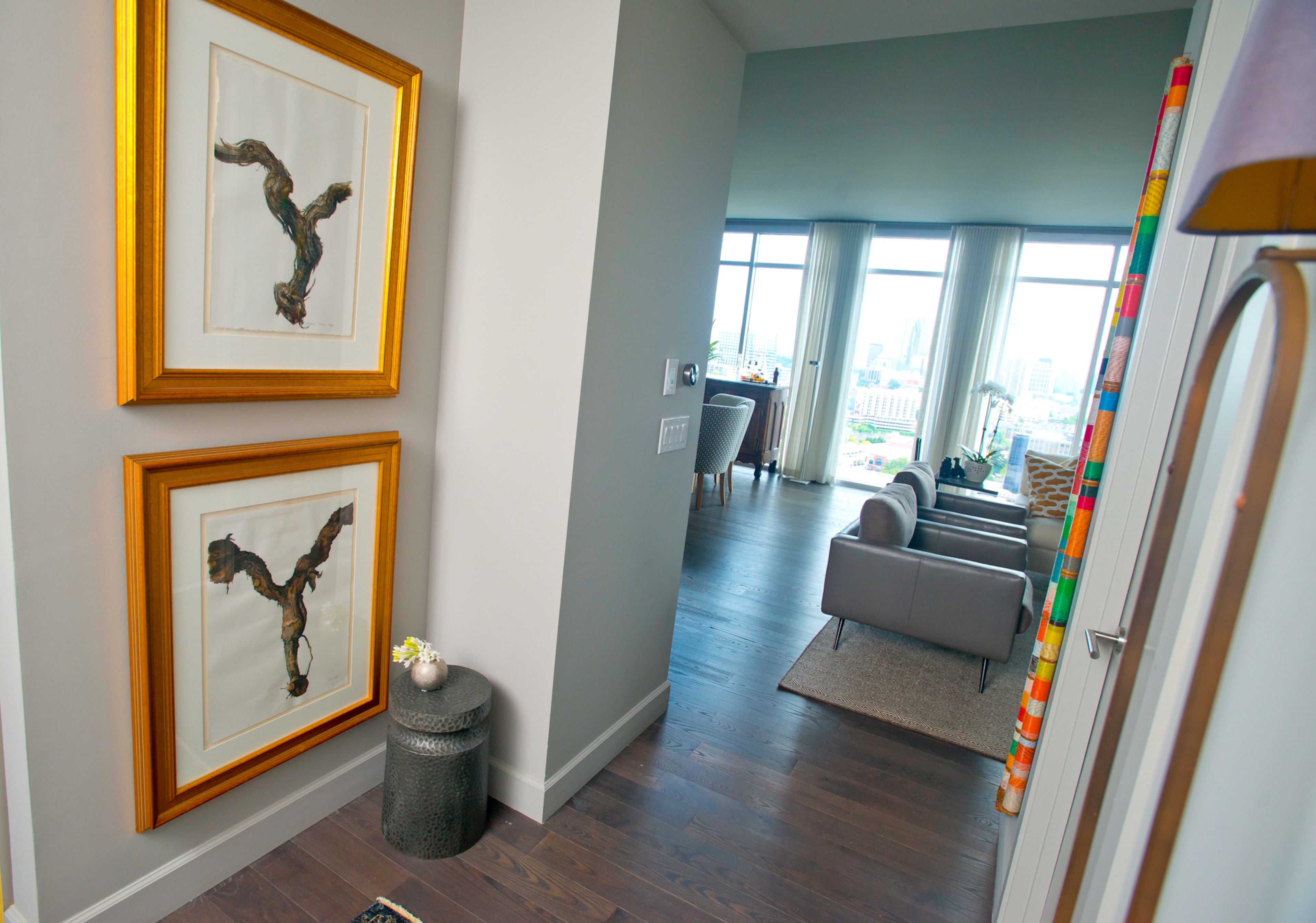 "We're avid wine collectors and drinkers," says homeowner Ross Jones. Two framed photographs of 100-year-old vines are featured inside the foyer of her Atlanta high-rise condo.