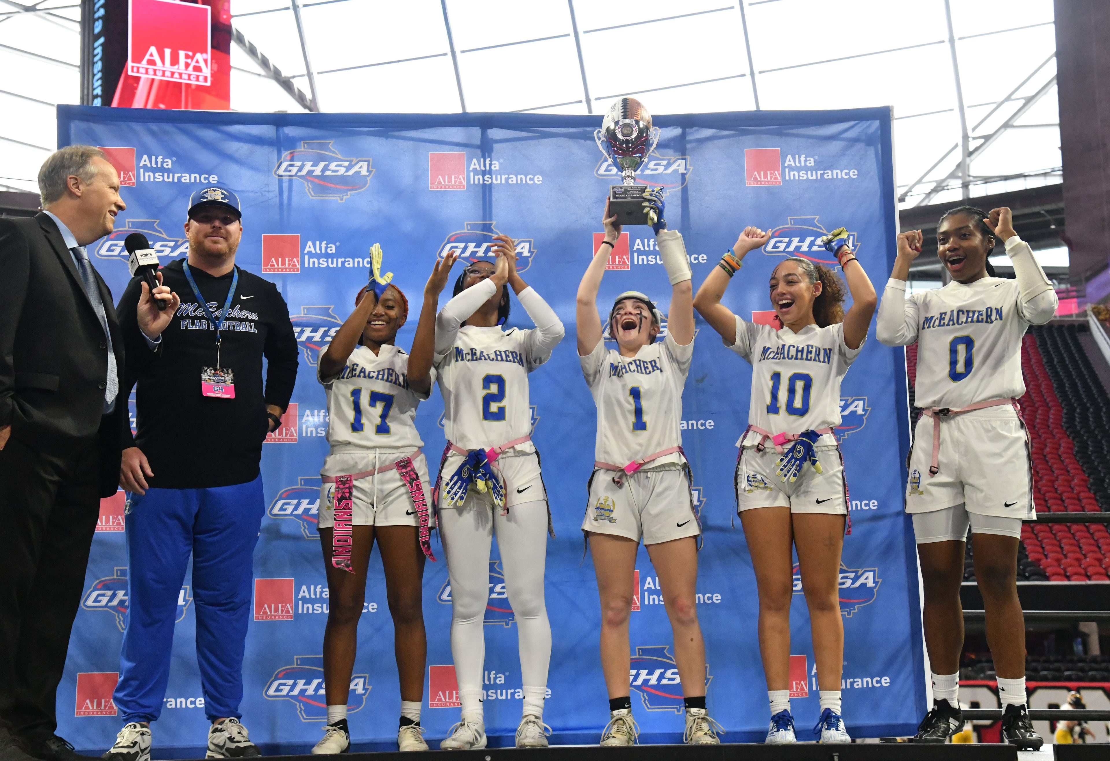 McEachern players celebrate their victory over Lambert in GHSA Division 4 Flag Football State Championship game at Mercedes-Benz Stadium, Wednesday, December 18, 2024, in Atlanta. McEachern won 26-6 over Lambert. (Hyosub Shin / AJC)