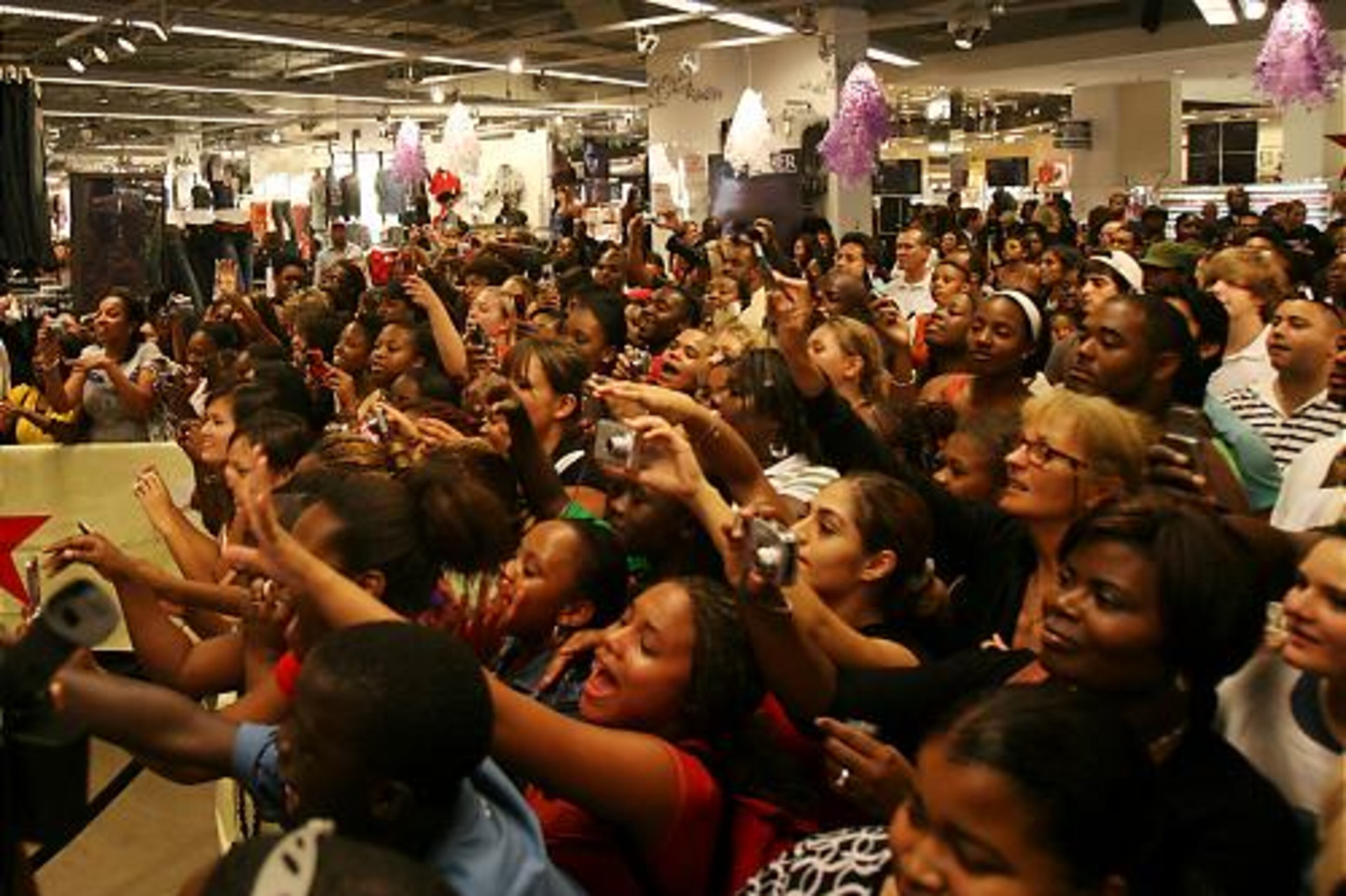 Fans welcome Usher to the stage as he debuts his new fragrance "Usher" at Macy's Lenox Square on Thursday.