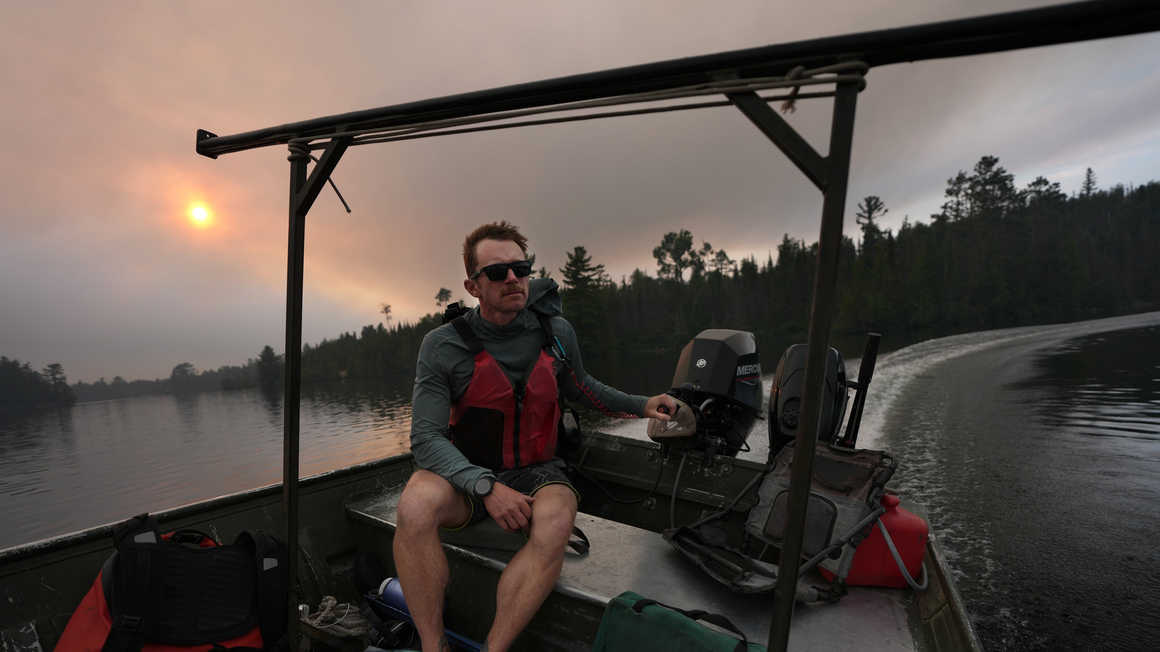 Willy Vosburgh, owner of Vosburgh's Custom Cabin Rentals on Moose Lake, uses a tow boat to evacuate canoeists from the Boundary Waters Canoe Area Wilderness after multiple wildfires burning there prompted its closure and evacuation Tuesday, July 14, 2026 in Ely, Minn. (Anthony Souffle/Minnesota Star Tribune via AP)