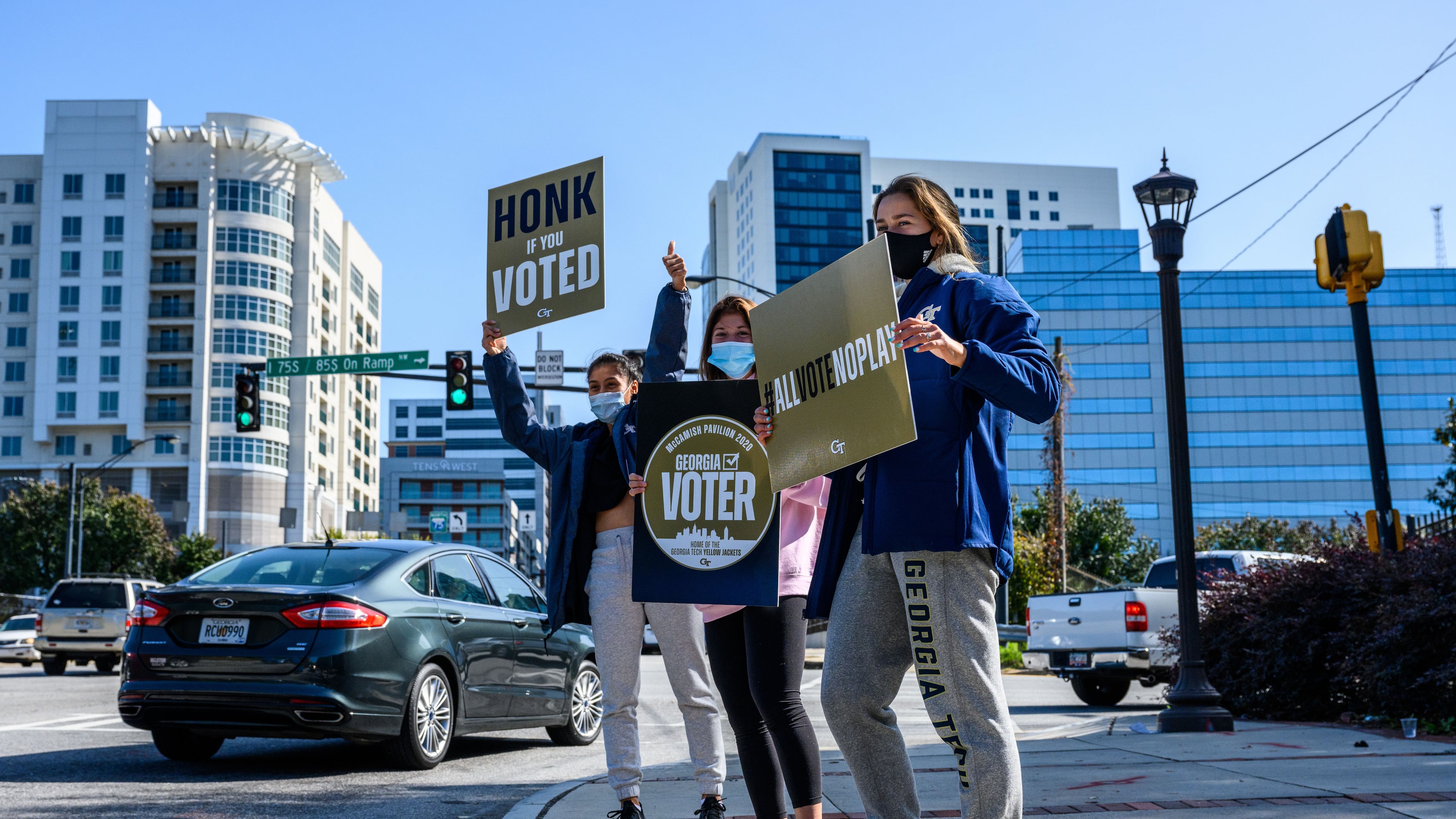 Georgia Tech women's tennis players (left to right) Victoria Flores, Ruth Marsh and Sophia Sassoli draw attention to the polling site at McCamish Pavilion Nov. 3, 2020.