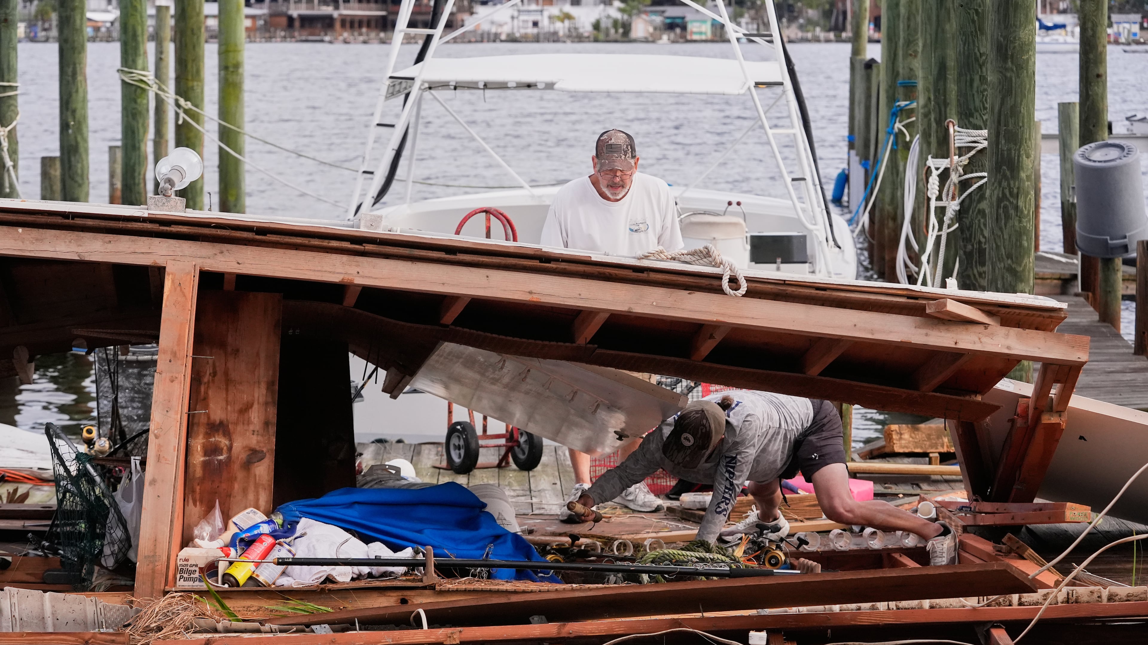 People retrieve belongings from a collapsed boat house in the aftermath of Hurricane Isaias in Destin, Fla., Saturday, Oct. 10, 2026. (AP Photo/Gerald Herbert)