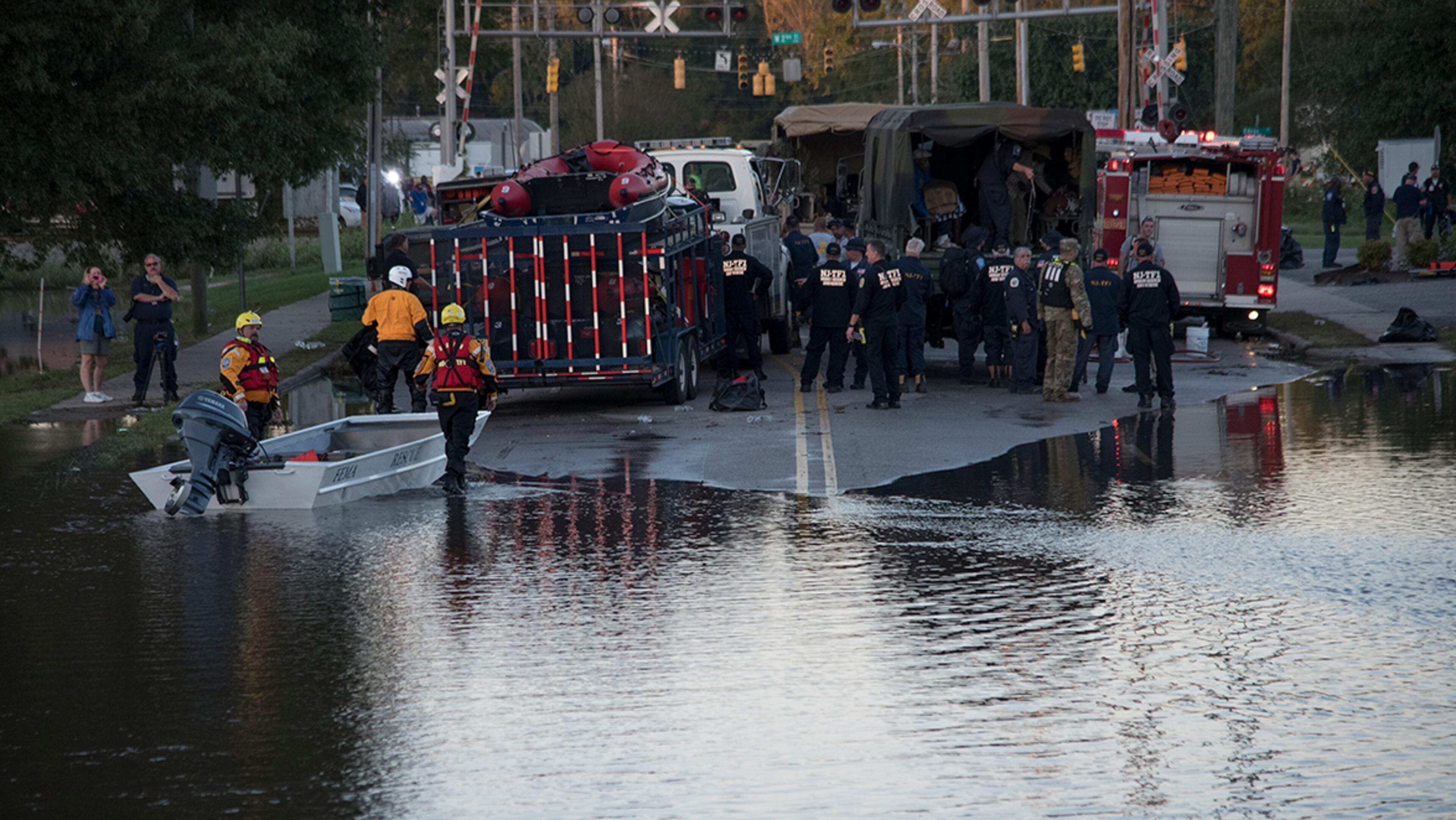 Swift water rescue teams stage at the foot of Martin Luther King Jr. Drive as part of the rescue efforts from floodwaters caused by rain from Hurricane Matthew in Lumberton, N.C., Monday, Oct. 10, 2016. (AP Photo/Mike Spencer)