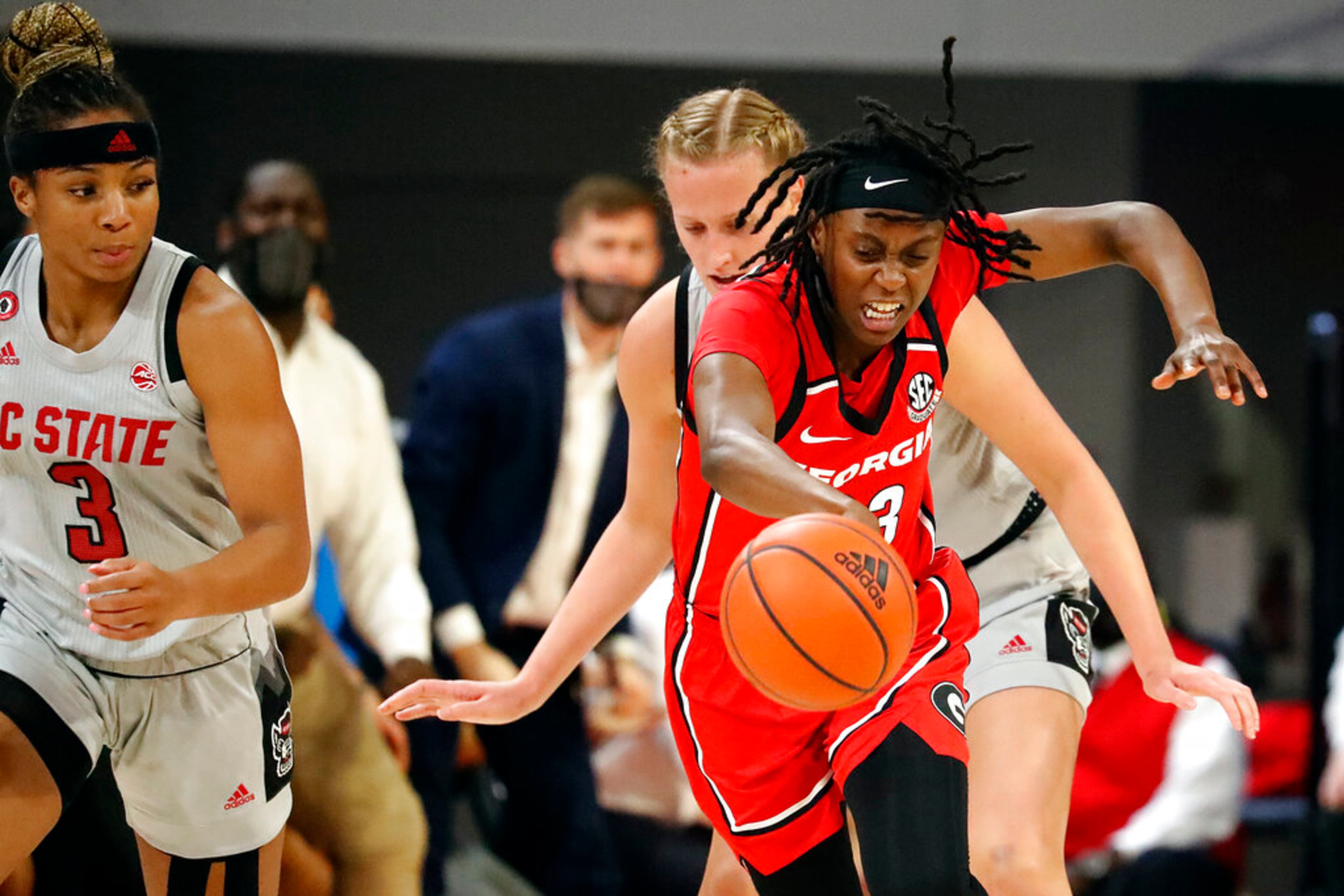Georgia's Que Morrison, front right, tries to steal the ball from North Carolina State's Elissa Cunane, back right, with North Carolina State's Kai Crutchfield, left, watching during the first half of an NCAA college basketball game, Thursday, Dec. 16, 2021, in Raleigh, N.C. Morrison was called for a foul on the play. (AP Photo/Karl B. DeBlaker)
