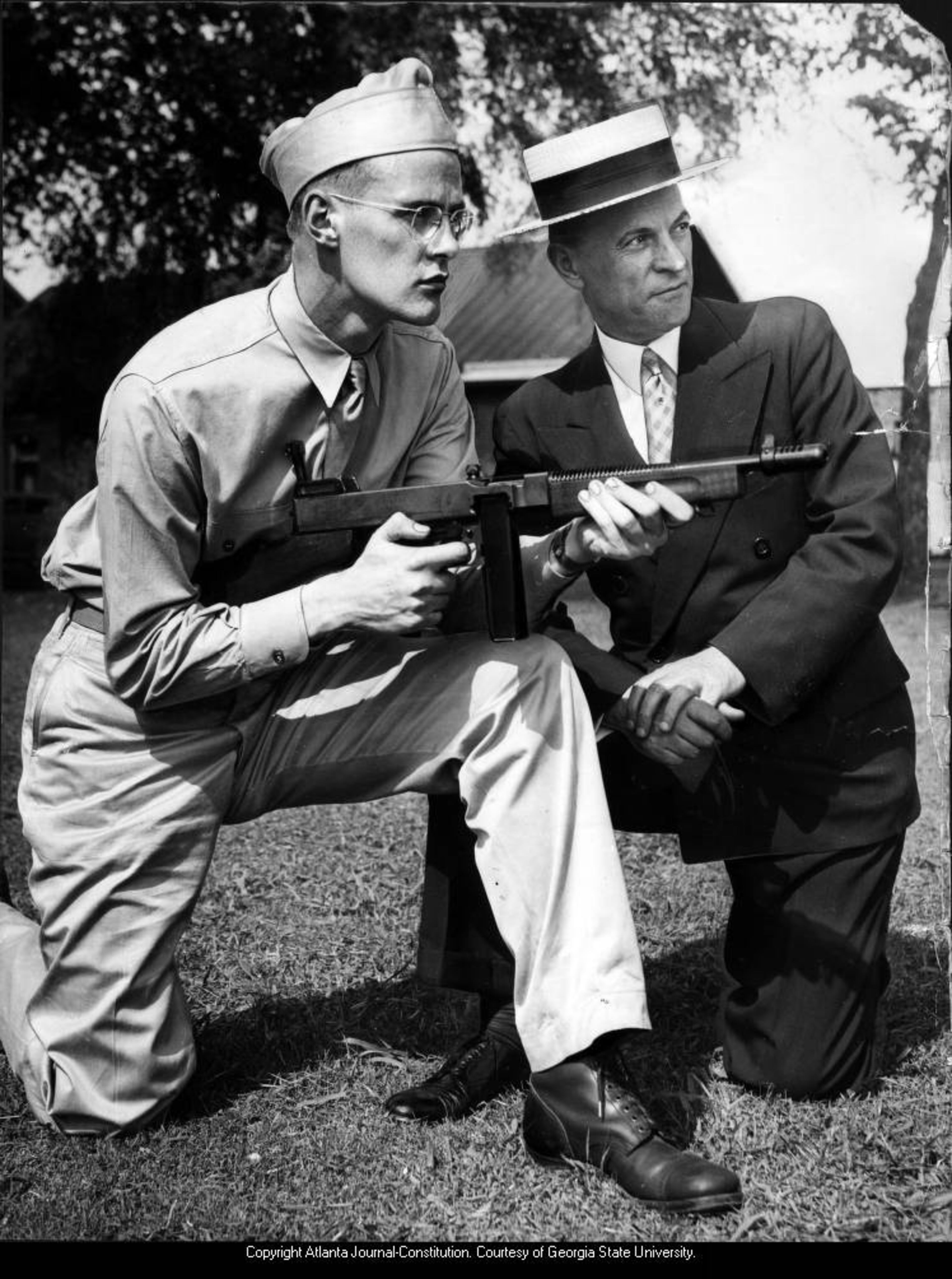 June 1947 -- An unidentified soldier demonstrates automatic rifle shooting while a visitor looks on.