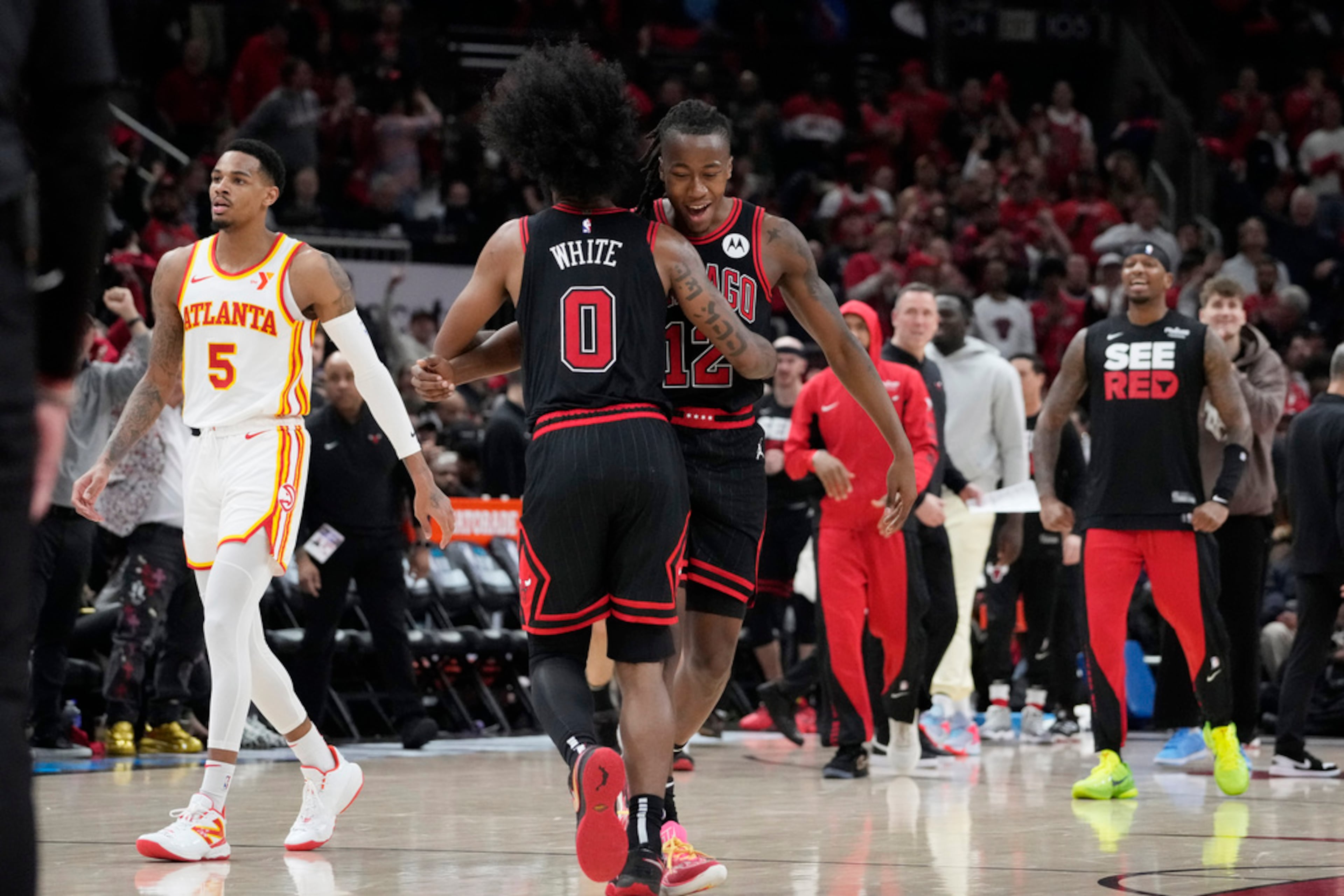 Chicago Bulls guard Coby White (0) celebrates with guard Ayo Dosunmu after a Bulls basket during the second half of the team's NBA basketball play-in tournament game against the Atlanta Hawks in Chicago, Wednesday, April 17, 2024. The Bulls won 131-116. (AP Photo/Nam Y. Huh)
