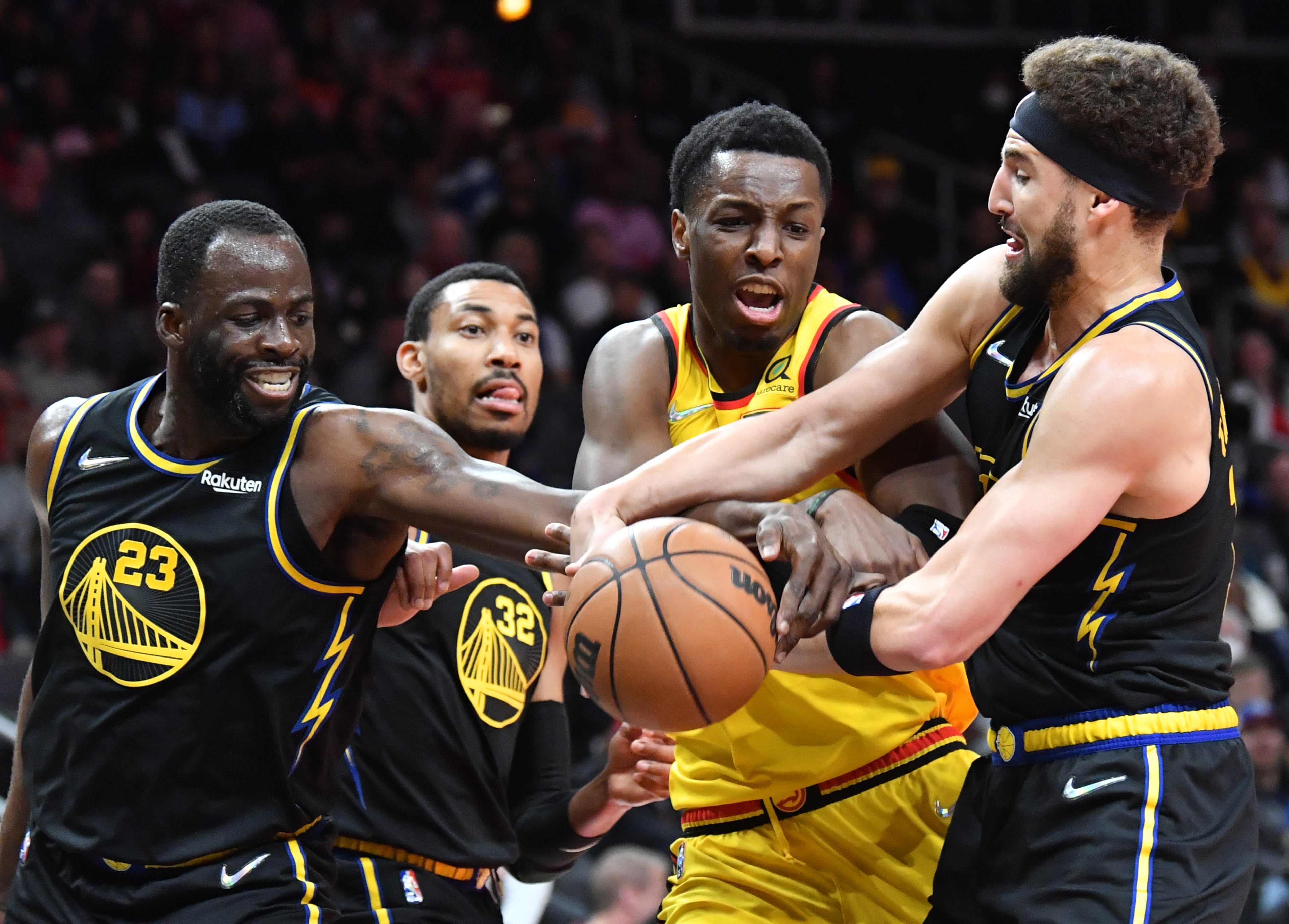 Hawks' forward Onyeka Okongwu (17) fights for a rebound with Golden State Warriors' forward Draymond Green (23) and guard Klay Thompson (right) during the first half in an NBA basketball game at State Farm Arena on Friday, March 25, 2022. (Hyosub Shin / Hyosub.Shin@ajc.com)