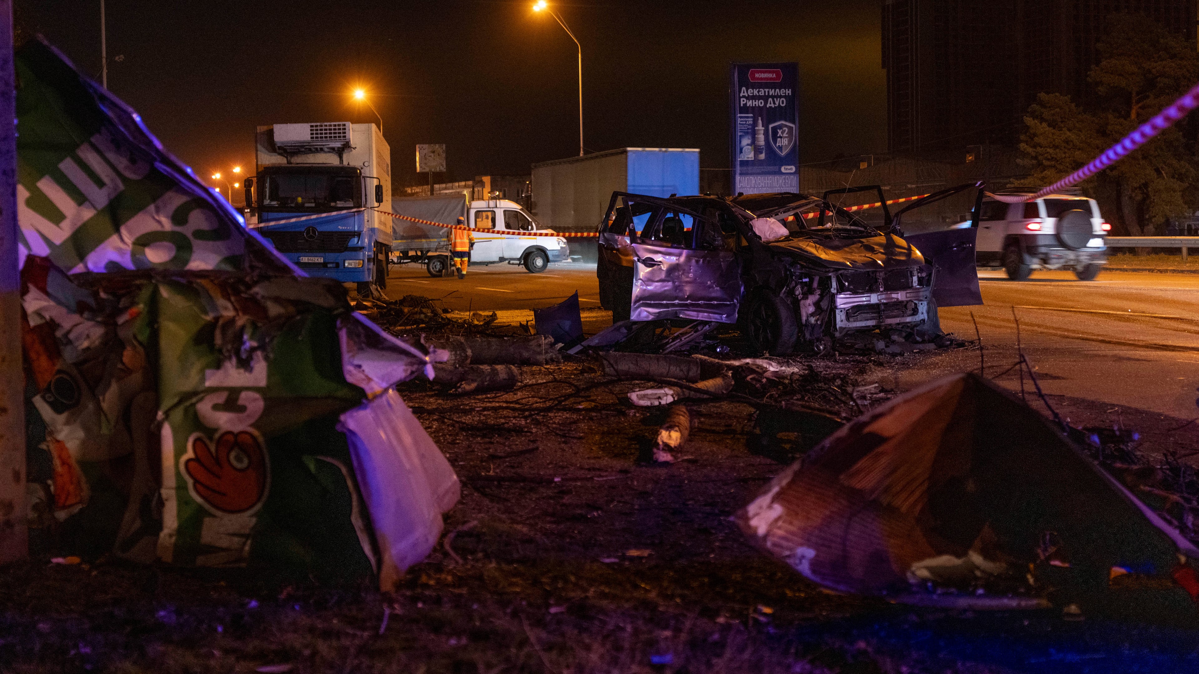 Emergency workers clear debris and damaged road infrastructure near a destroyed car following a Russian overnight strike in Kyiv, Ukraine, Tuesday, Oct. 27, 2026. (AP Photo/Dan Bashakov)