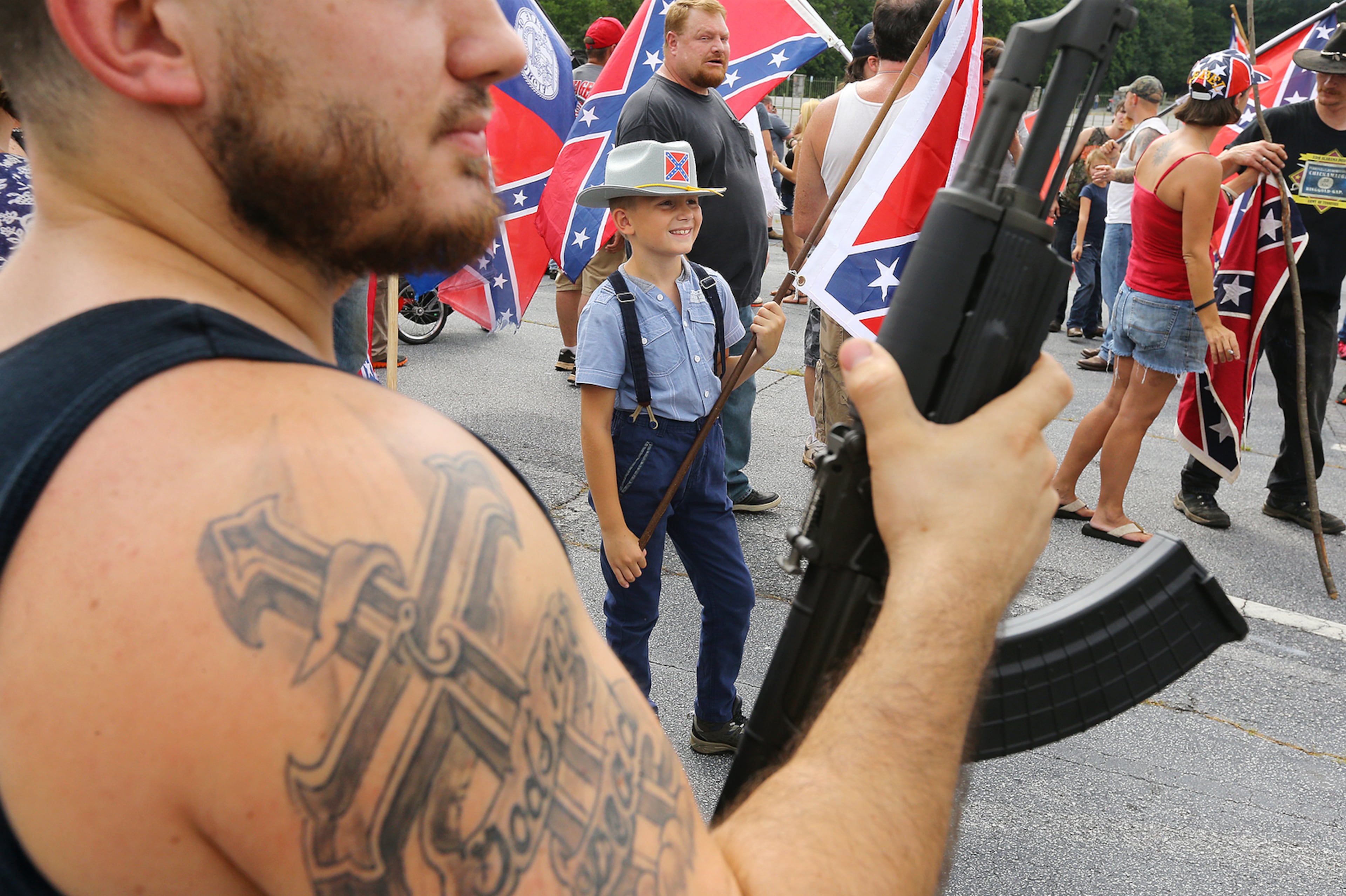 FLAGS AND GUNS--080215 STONE MOUNTAIN: Hundreds of pro-Confederate flag and gun supporters rally at Stone Mountain Park on Saturday, August 1, 2015, in Stone Mountain. At center is 9-year-old Jack Murlin, Druid Hills, who attended with his dad John Murlin in support of Southern Heritage. Curtis Compton / ccompton@ajc.com