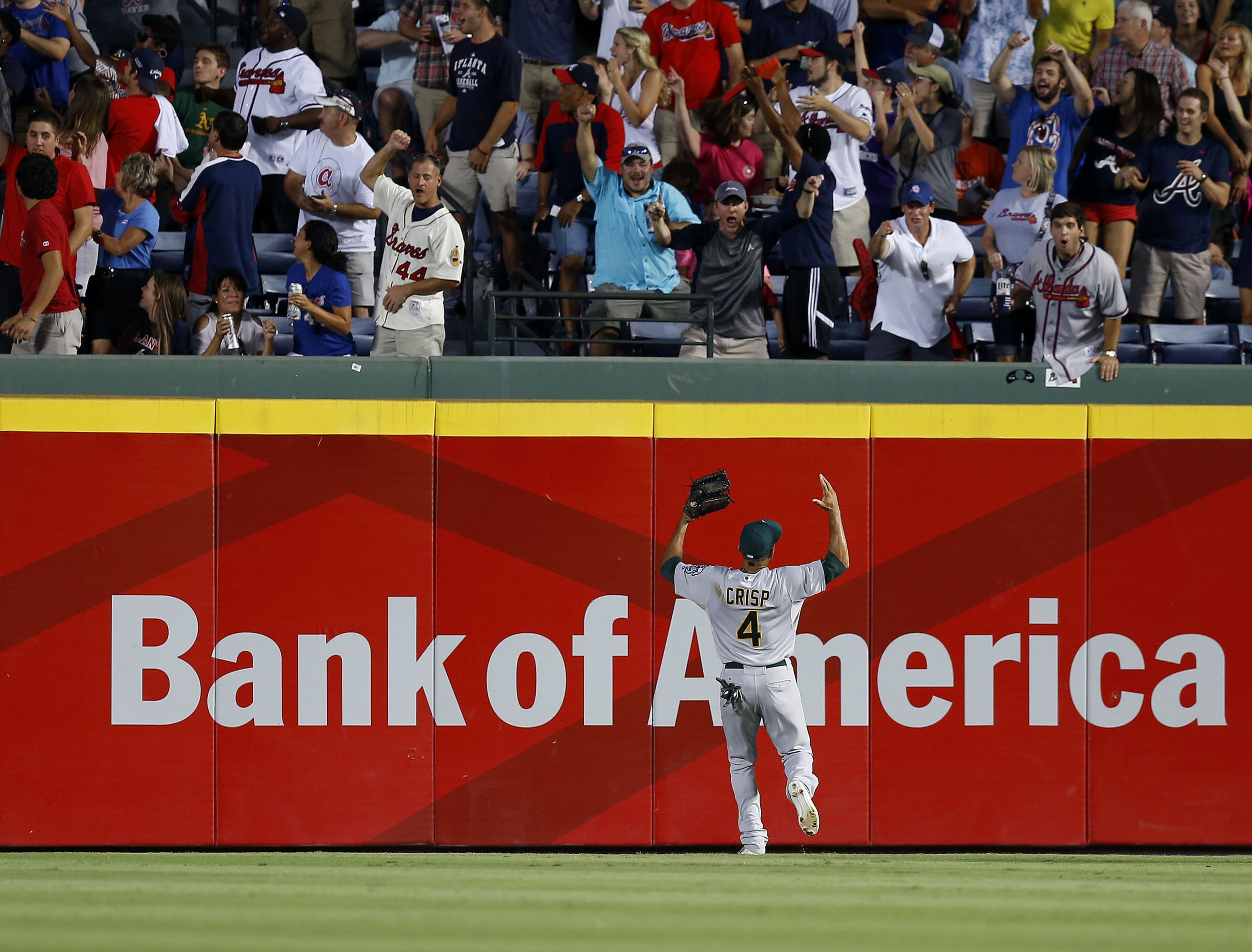 ATLANTA, GA - AUGUST 15: Centerfielder Coco Crisp #4 of the Oakland Athletics loses track of a ball that bounces over the fence for a ground rule double hit by Chris Johnson #23 of the Atlanta Braves (not pictured) in the third inning of the game at Turner Field on August 15, 2014 in Atlanta, Georgia. (Photo by Mike Zarrilli/Getty Images)