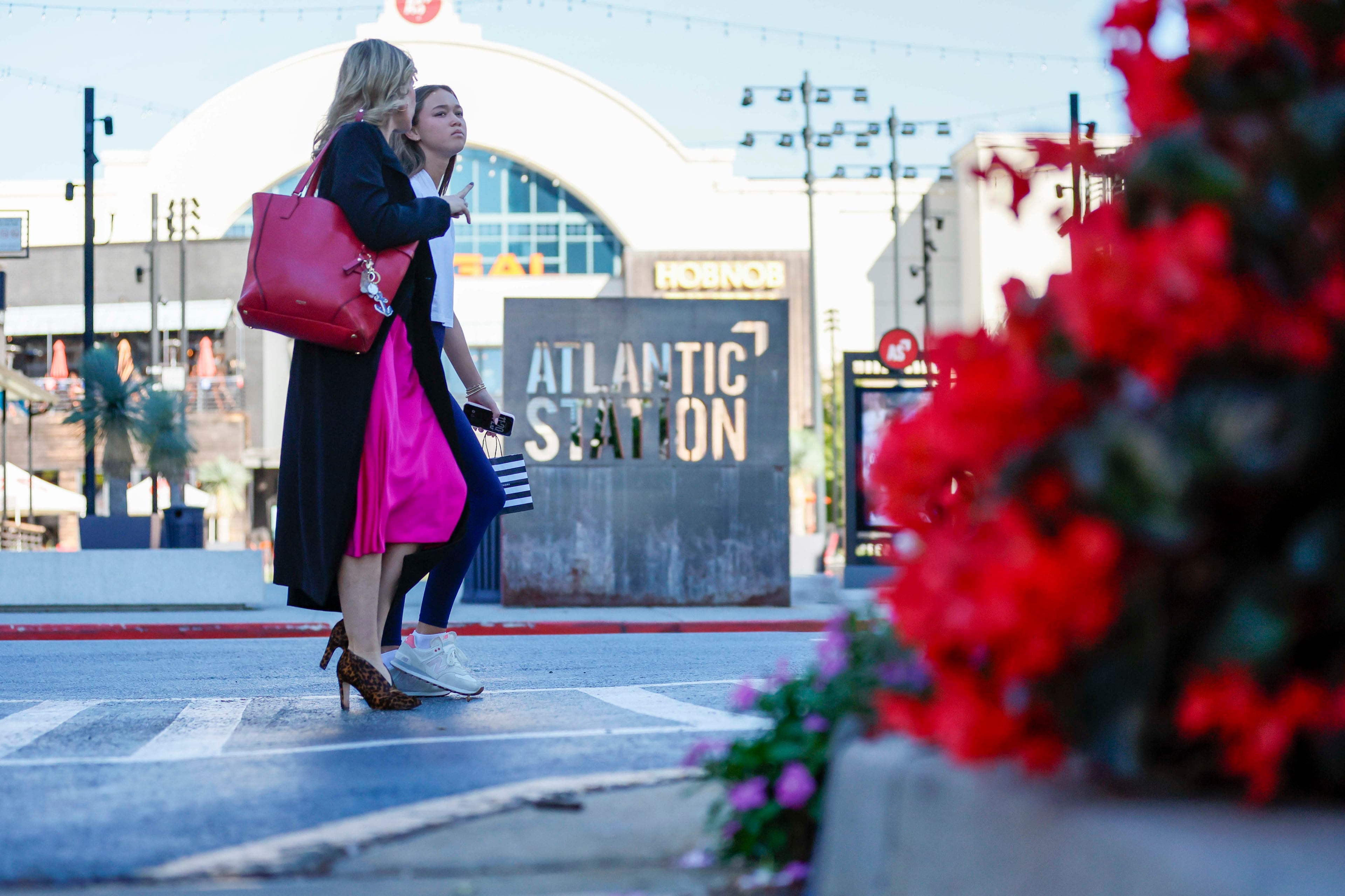 Pedestrians walk in front of the Atlantic Station sign in the main square on Thursday, Oct. 16, 2025. (Miguel Martinez/AJC)