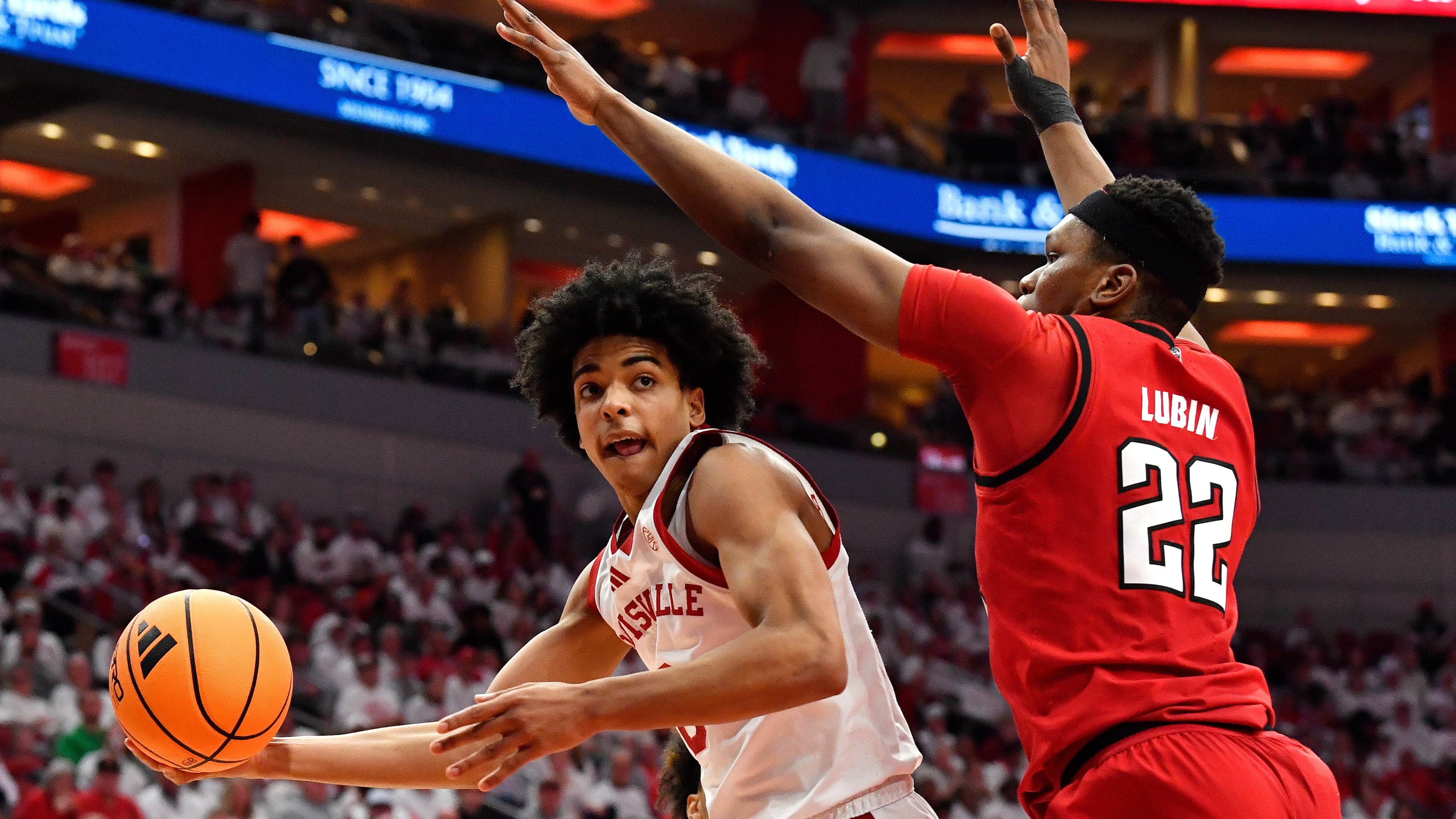 Louisville guard Mikel Brown Jr., left, passes the ball away from North Carolina State forward Ven-Allen Lubin (22) during the second half of an NCAA college basketball game in Louisville, Ky., Monday, Feb. 9, 2026. (AP Photo/Timothy D. Easley)