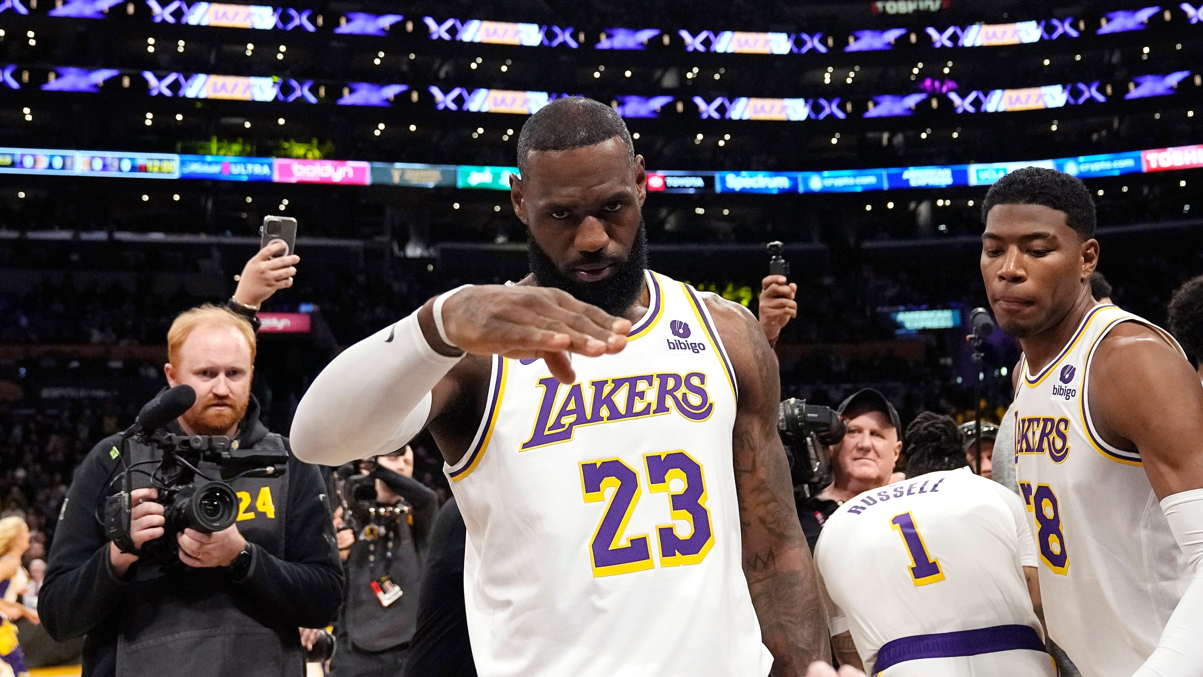 FILE - Los Angeles Lakers forward LeBron James salutes public address announcer Lawrence Tanter prior to an NBA basketball game against the Denver Nuggets Saturday, March 2, 2024, in Los Angeles. (AP Photo/Mark J. Terrill,File)