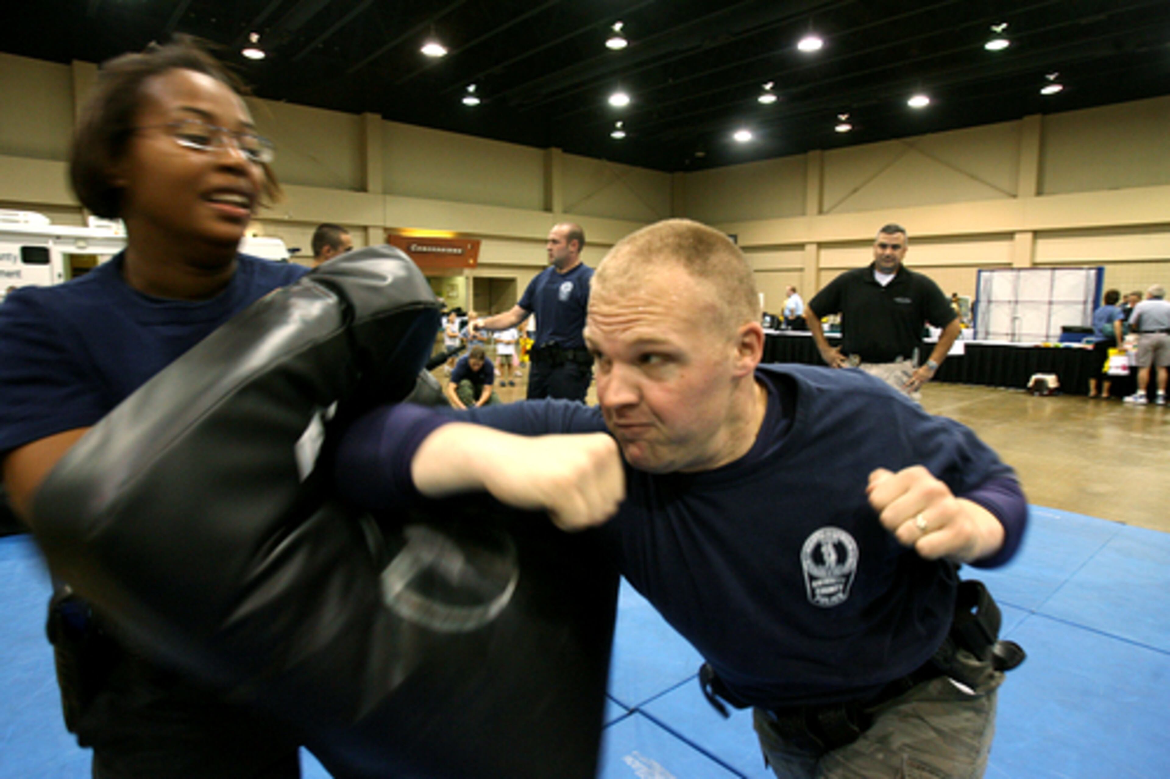 Gwinnett County Police Officers Ronnetta Coates (left) and Jason Allen (right) show a defensive technique called a horizontal elbow strike at the 10th annual COPS (Community Oriented Police Services) Festival at the Gwinnett Convention Center in Duluth, Ga.