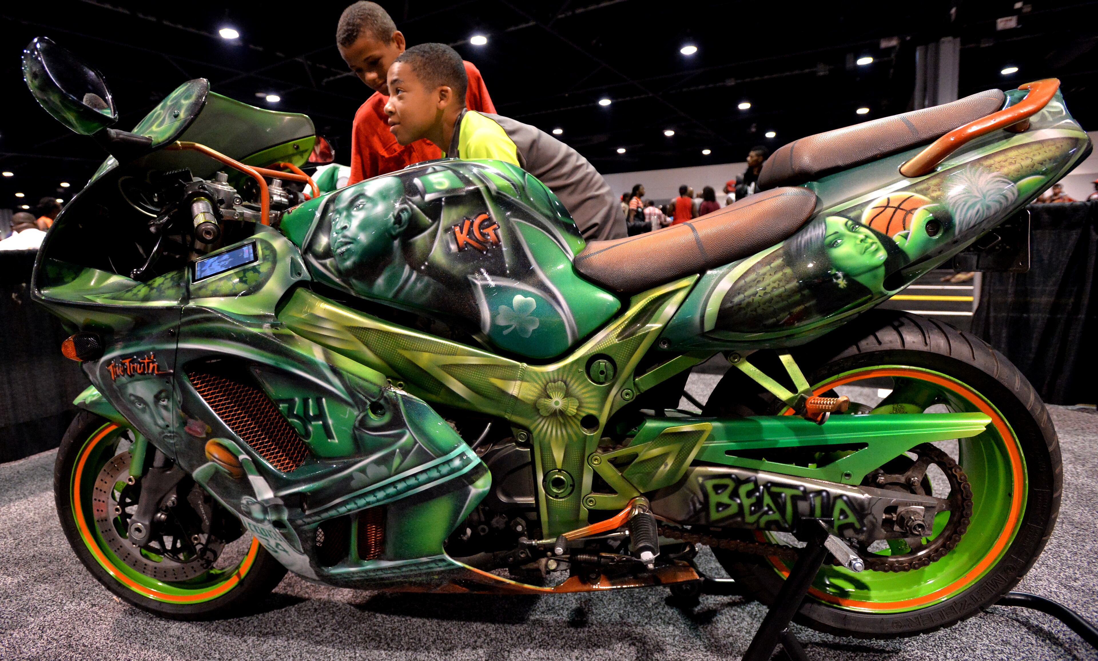 June 22, 2013 Atlanta - Isaiah Harrison (background), 12, and Robert Glover (foreground), 11, take a look at a Suzuki 750 with Boston Celtic theme during the V-103/WAOK 10th Annual Car & Bike Show at the Georgia World Congress Center on Saturday, June 22, 2013. The V-103/WAOK Car and Bike Show has something for everyone, age 16-54, from the hardcore car & bike enthusiasts to the casual attendee there for an overall great event, including: - The Street Alley showcasing hundreds of amazing custom vehicles and motorcycles. HYOSUB SHIN / HSHIN@AJC.COM