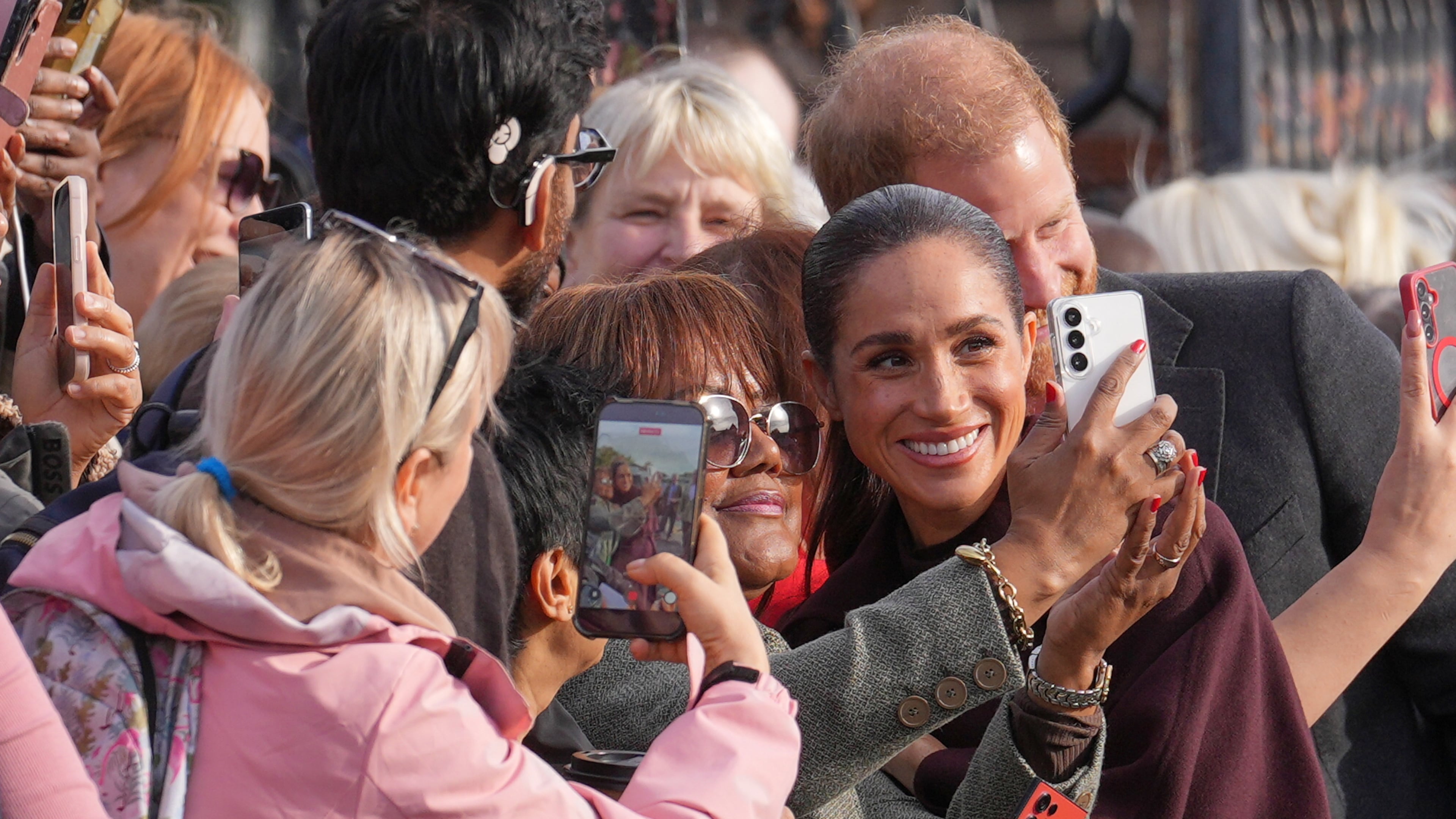 Britain's Prince Harry and Meghan, Duke and Duchess of Sussex pose for photographs with members of the public as they arrive for a visit to The Community Recording Studio in Nottingham, England, Thursday, Oct. 15, 2026. (AP Photo/Maja Smiejkowska)