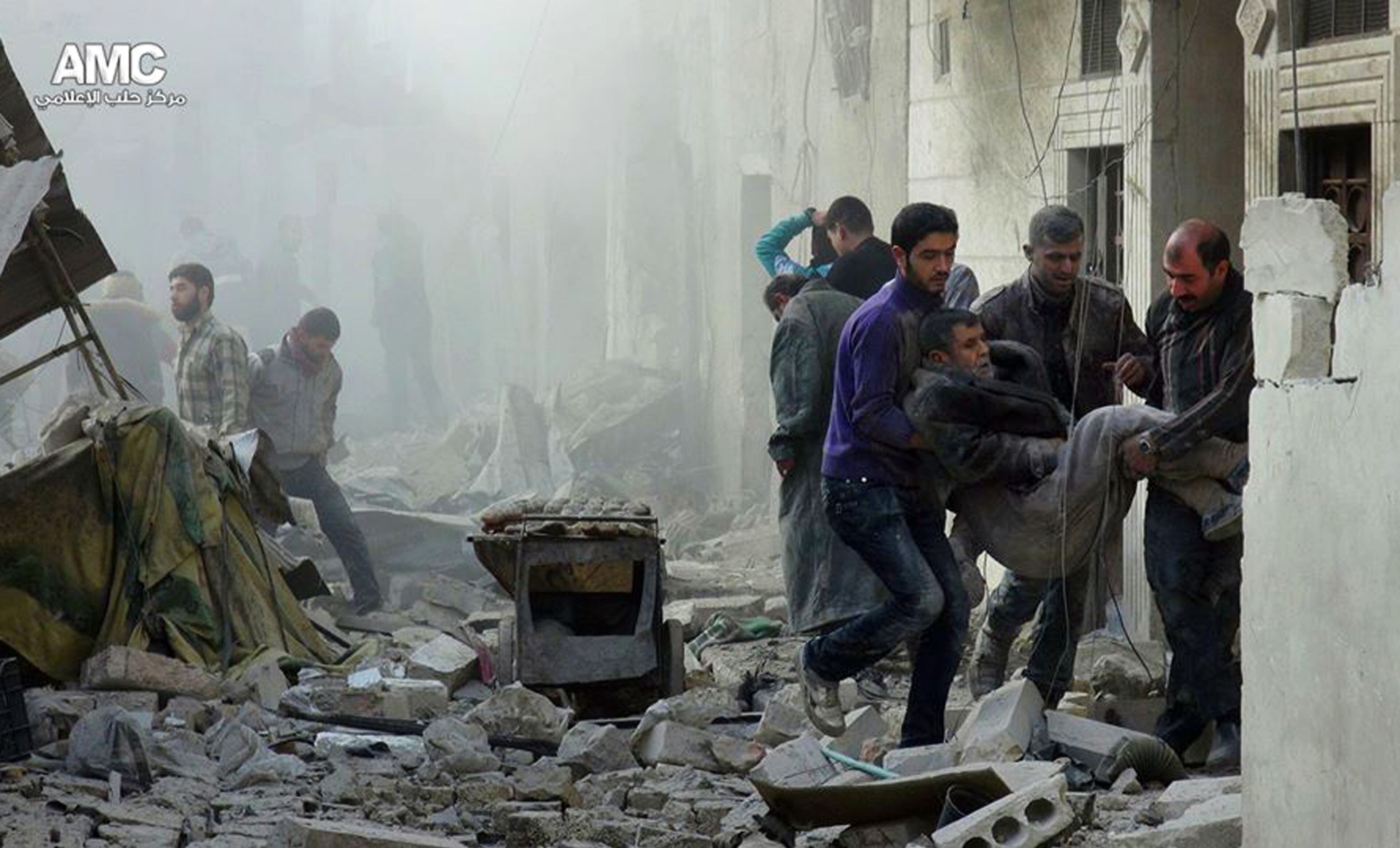 Syrians holding a wounded man being removed from the scene of a Syrian government airstrike in Aleppo, Syria, Dec. 17, 2013. The country's conflict, now in its third year, appears to have escalated in recent weeks as both sides maneuver ahead of 2014 planned peace talks and ignore calls for a cease-fire. (AP Photo/Aleppo Media Center, AMC)