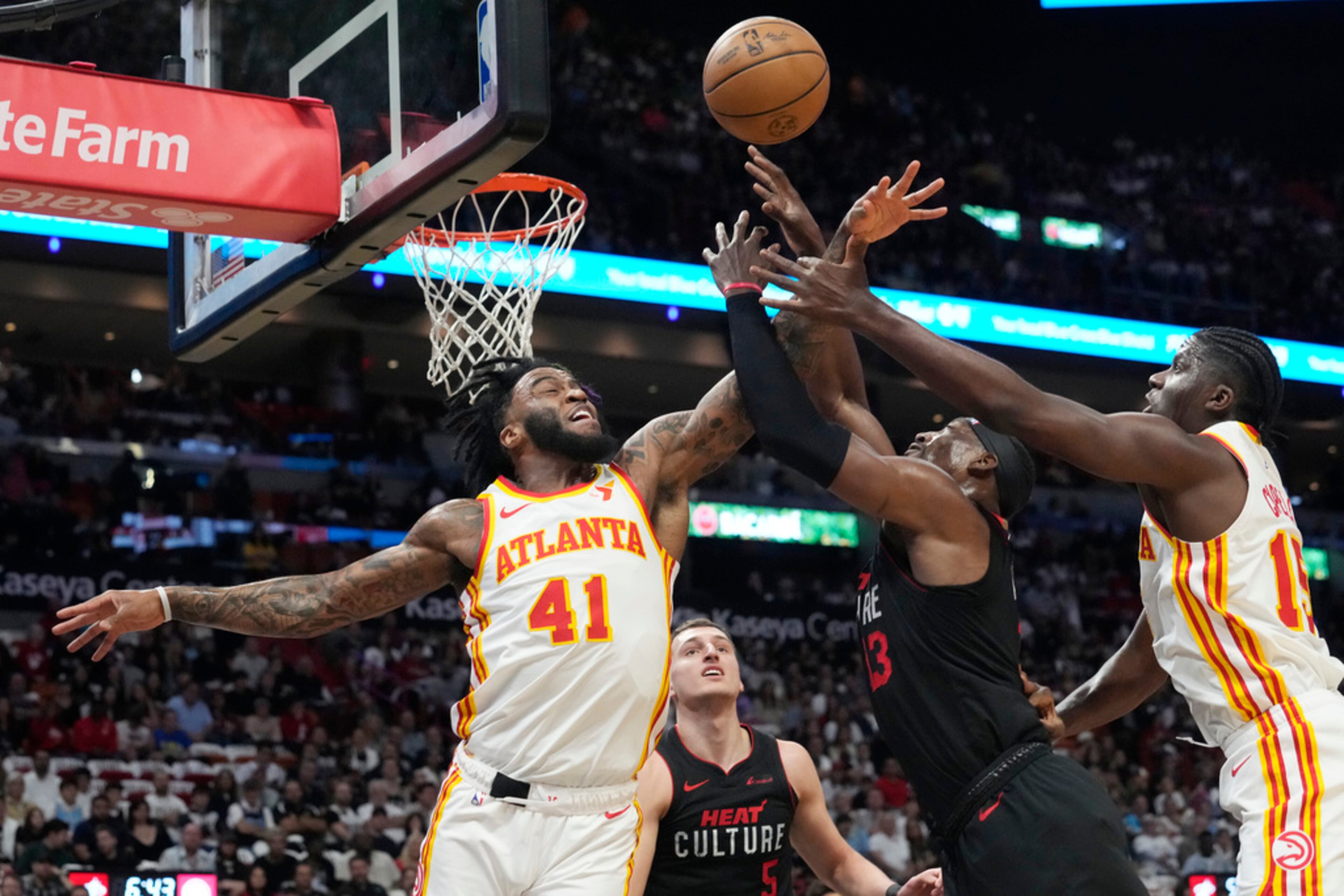 Atlanta Hawks forward Saddiq Bey (41), center Clint Capela (15) and Miami Heat center Bam Adebayo (13) go after a rebound during the first half of an NBA basketball game, Friday, Jan. 19, 2024, in Miami. (AP Photo/Marta Lavandier)