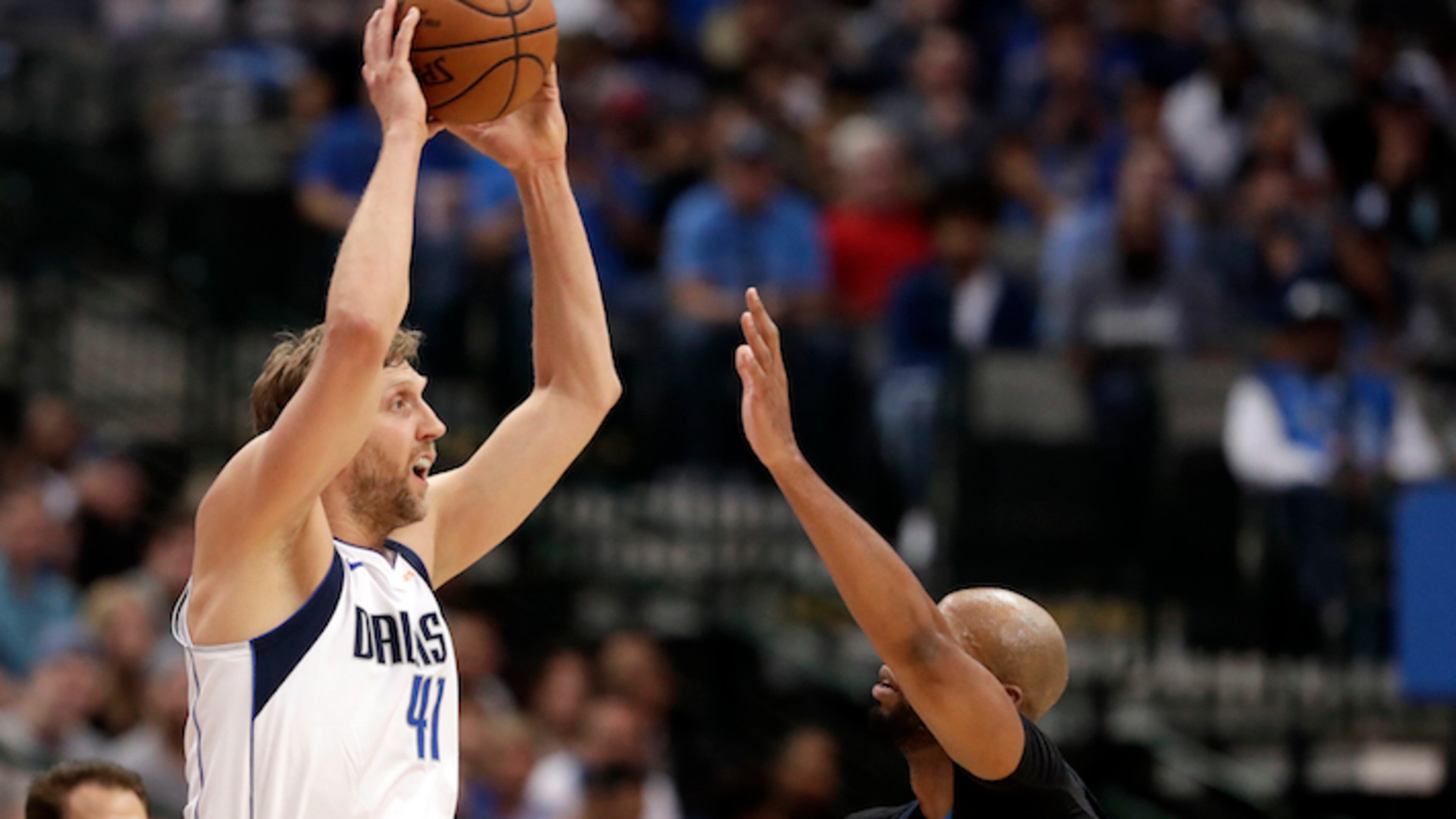 Dallas Mavericks' Dirk Nowitzki (41) of Germany passes the ball as Minnesota Timberwolves' Taj Gibson defends during an NBA basketball game in Dallas, Friday, March 30, 2018. (AP Photo/Tony Gutierrez)