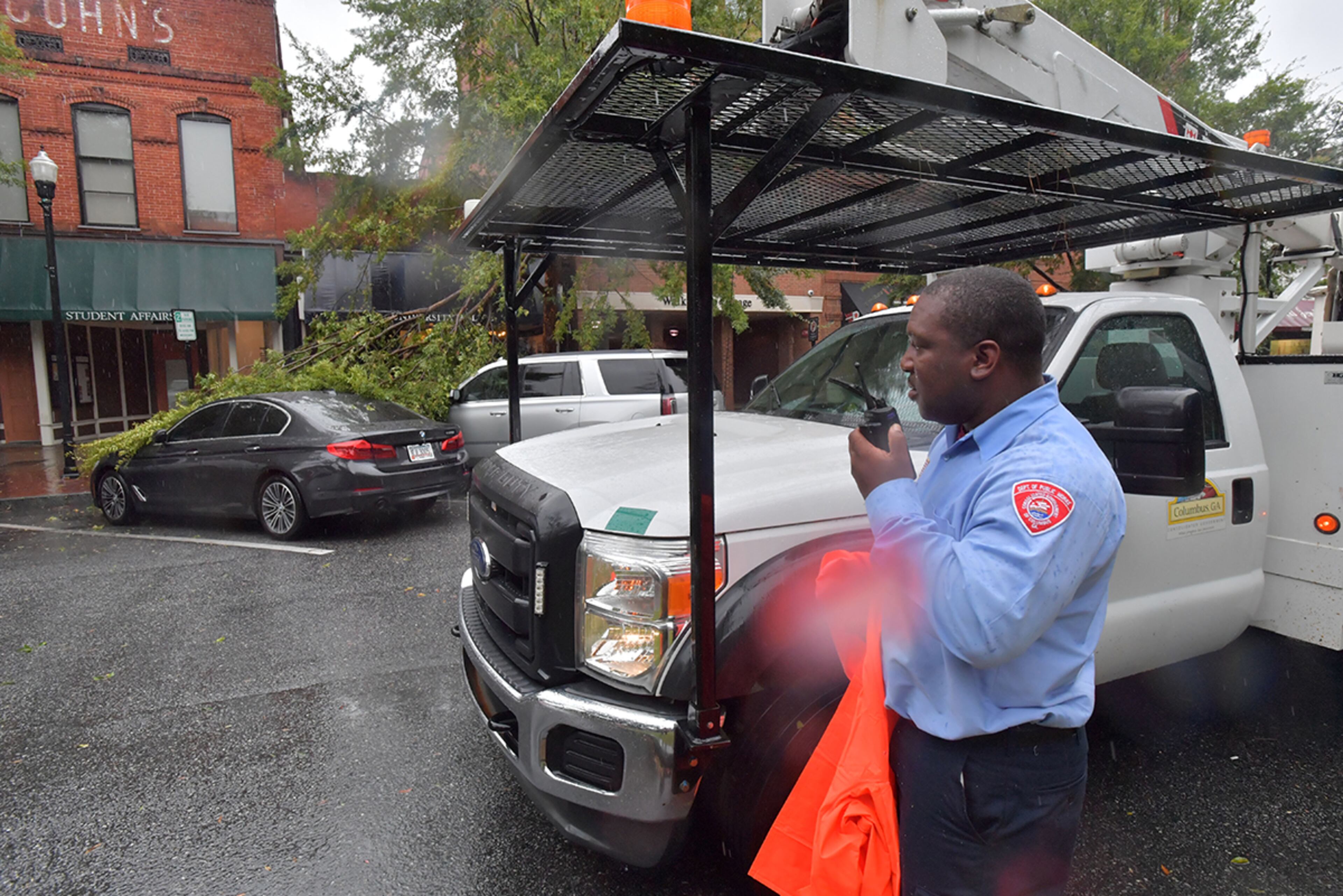 September 11, 2017 Columbus - Jabez Davis, with Department Public Service at the city of Columbus, uses a two-way radio to communicate with headquarters on Broadway in downtown Columbus on Monday, September 11, 2017. He had to move his car to a safe parking spot. The Georgia coast was hit hard Monday morning, with pounding rains, roaring winds and storm surge. More than 87,000 Georgia Power customers were without power in the Savannah area, as were another 96,000 from Brunswick and St. Simons south to St. Marys, at the Florida line. HYOSUB SHIN / HSHIN@AJC.COM