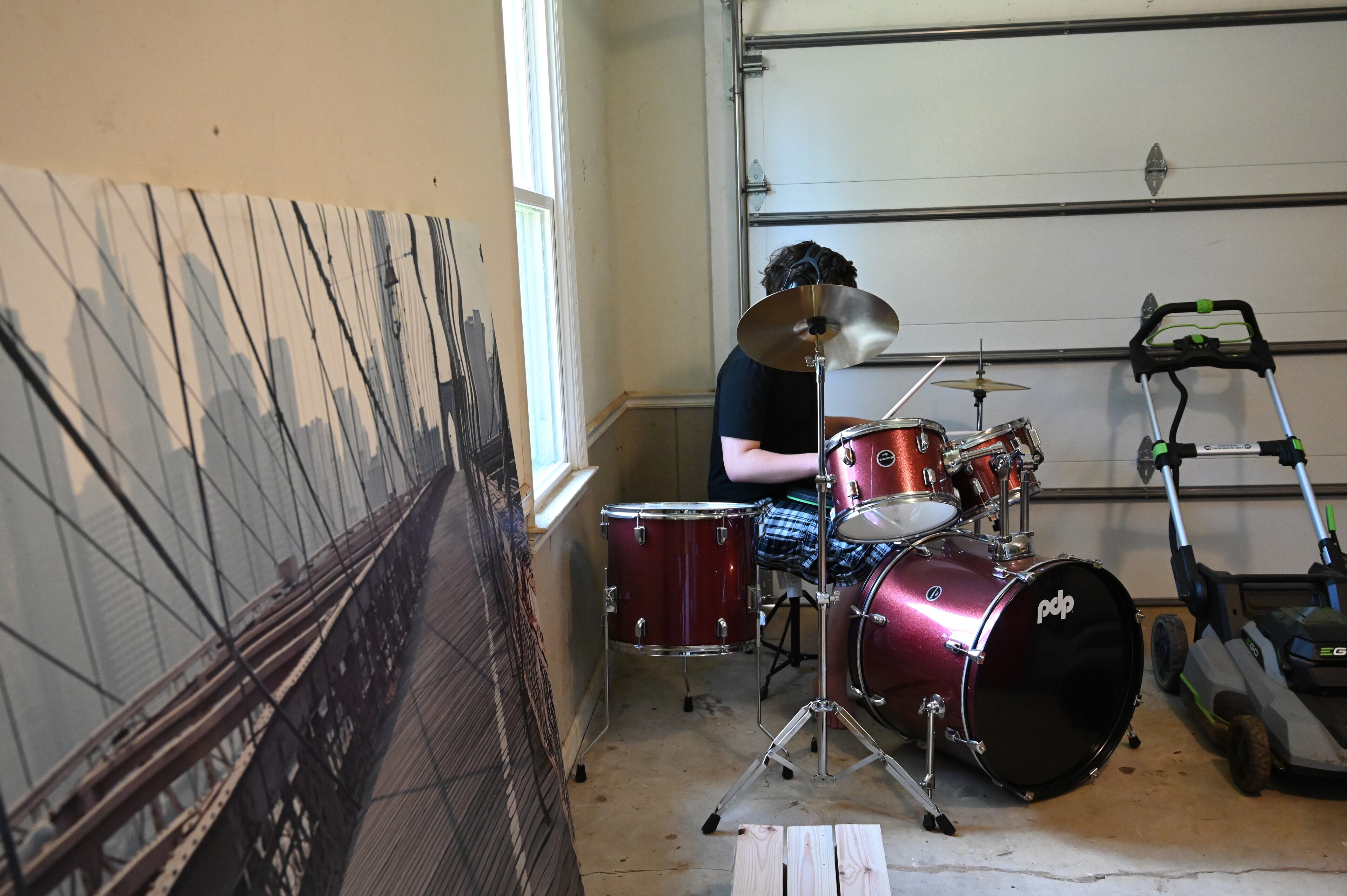 The Richards' son plays the drums at home on Saturday, June 21, 2025, in Watkinsville where he attends high school classes co-taught by a special education instructor. He finally feels like he's at a school where he feels accepted. (Hyosub Shin/AJC)