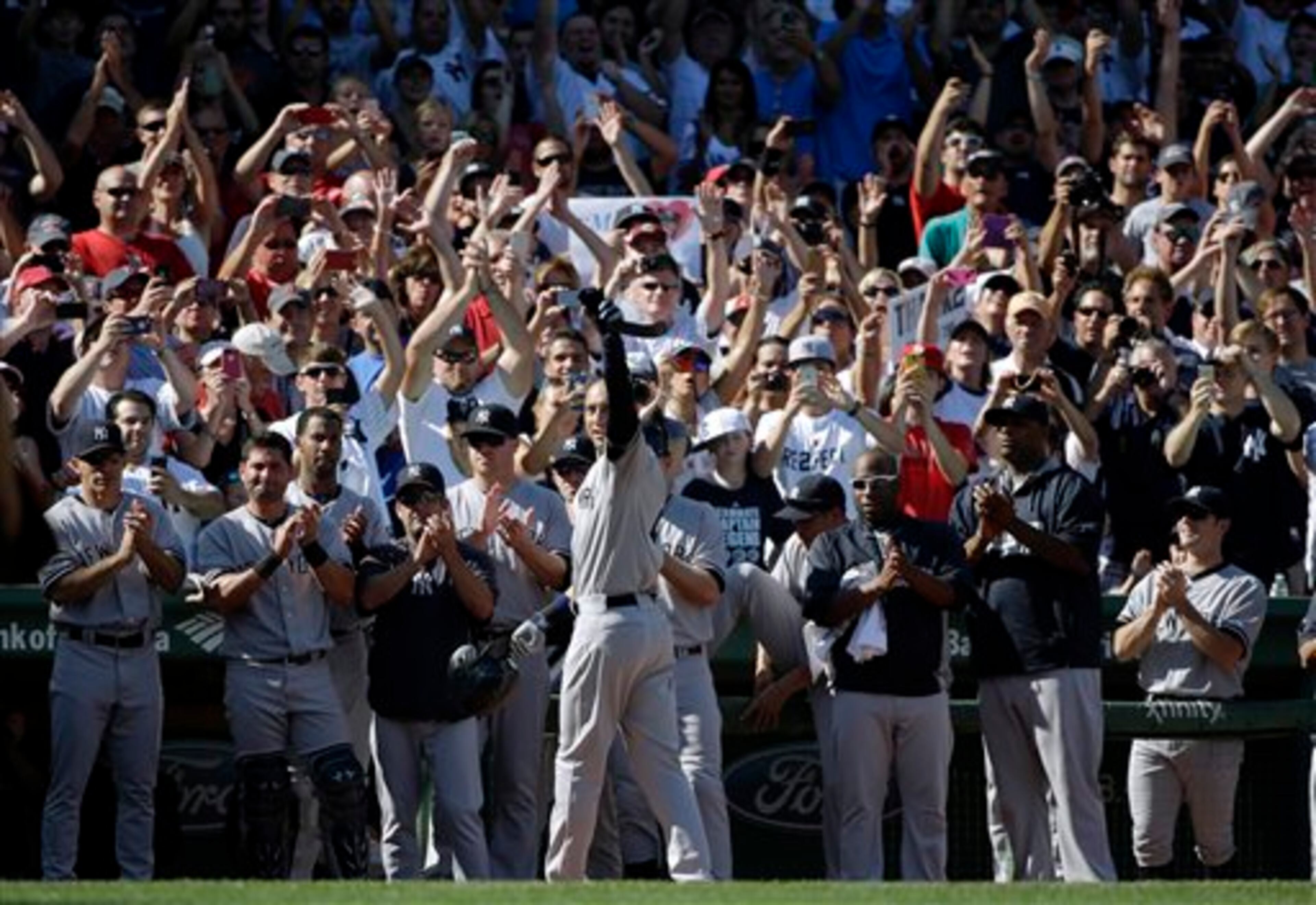 New York Yankees designated hitter Derek Jeter, center, acknowledges cheers from the crowd as he leaves the game after an RBI hit in the third inning of a baseball game against the Boston Red Sox Sunday, Sept. 28, 2014, at Fenway Park in Boston. This was the last at-bat in Jeter's baseball career. (AP Photo/Steven Senne)