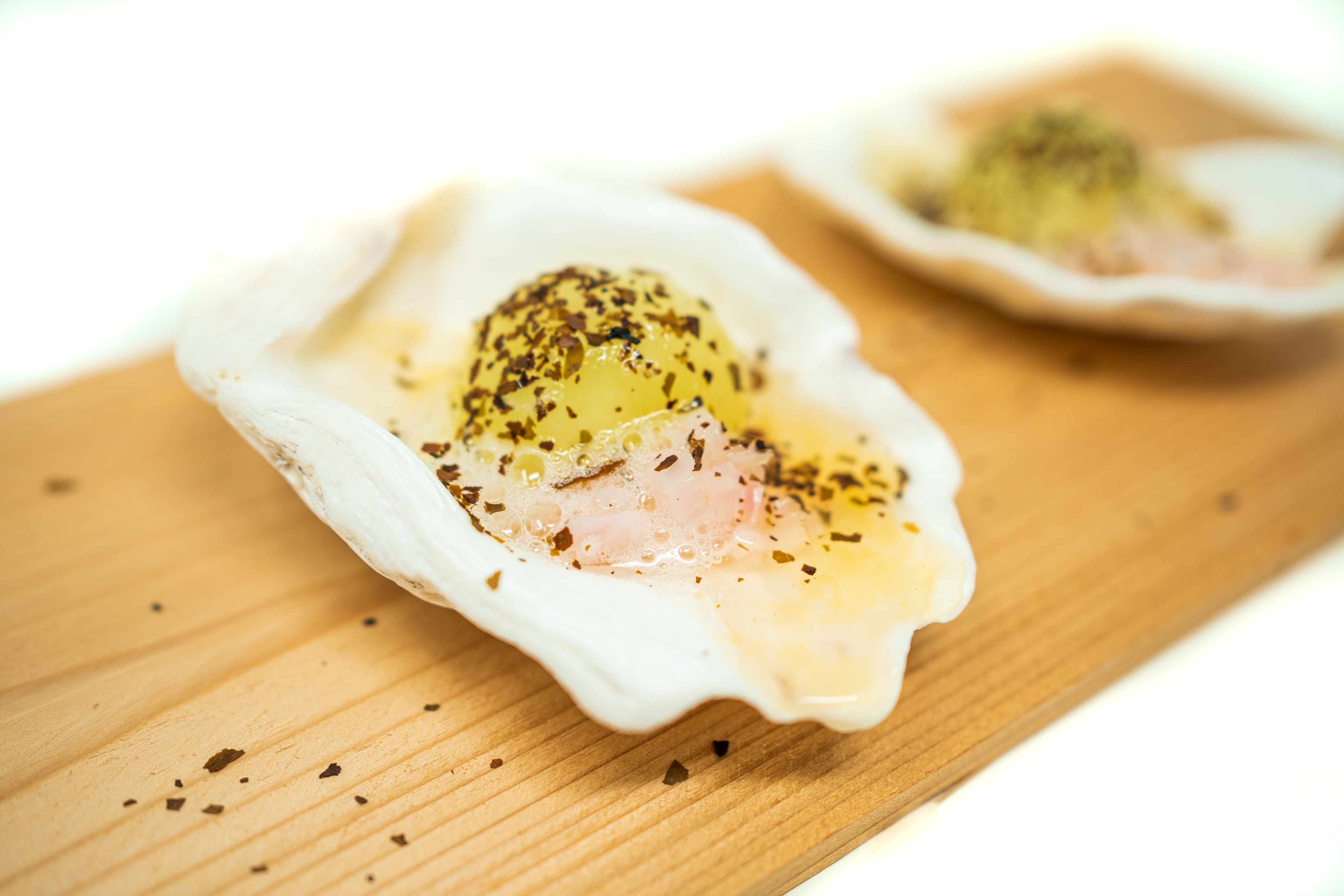 Service @ Seven’s cured honeydew with tomato dashi, pickled shallot and kelp sea foam served in a Denman Island oyster shell. (Courtesy of Service @ Seven)