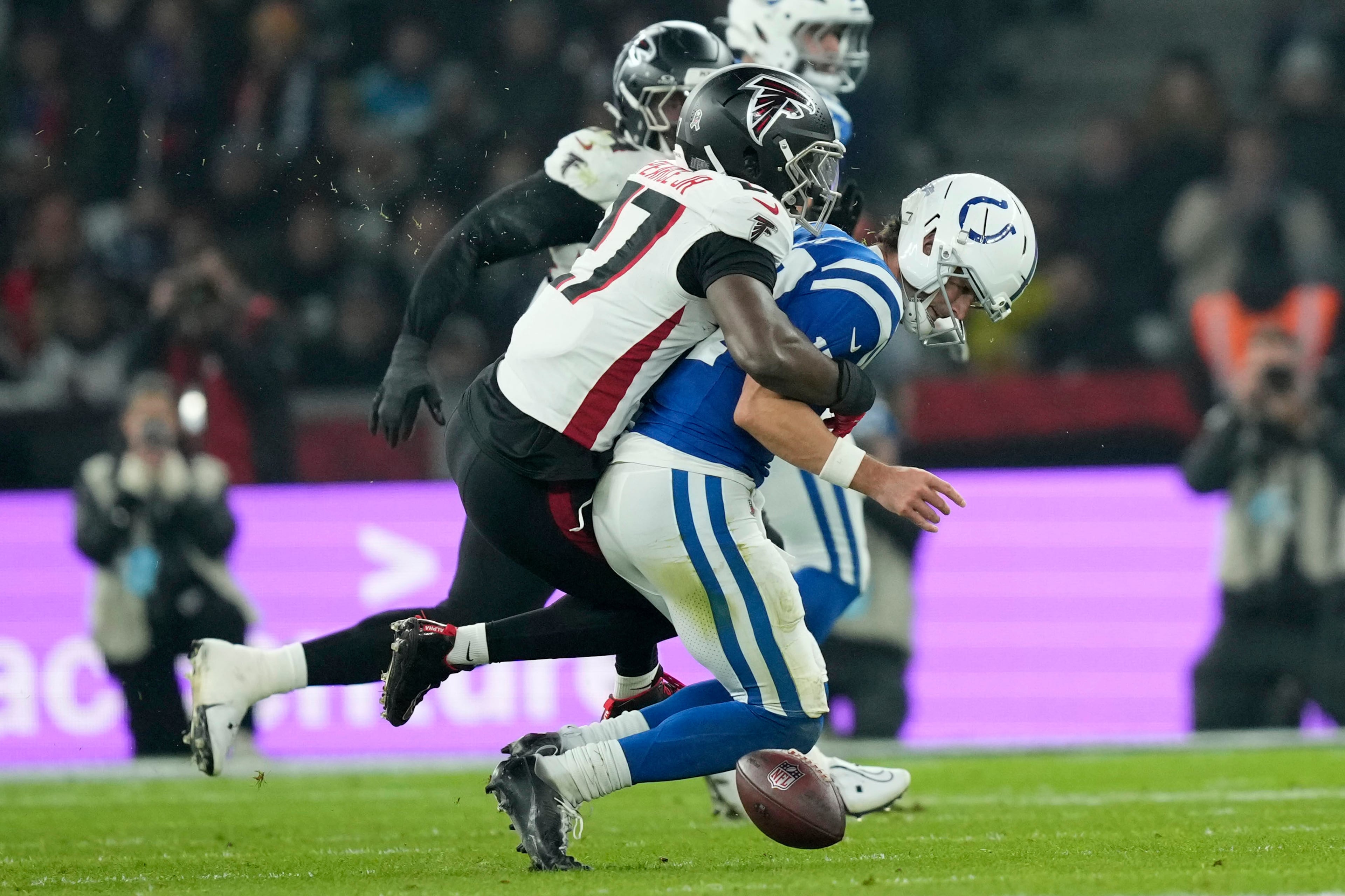 Indianapolis Colts quarterback Daniel Jones fumbles as he is hit by Atlanta Falcons linebacker James Pearce Jr. (27) during the second half of an NFL football game, Sunday, Nov. 9, 2025, in Berlin, Germany. (AP Photo/Ebrahim Noorozi)