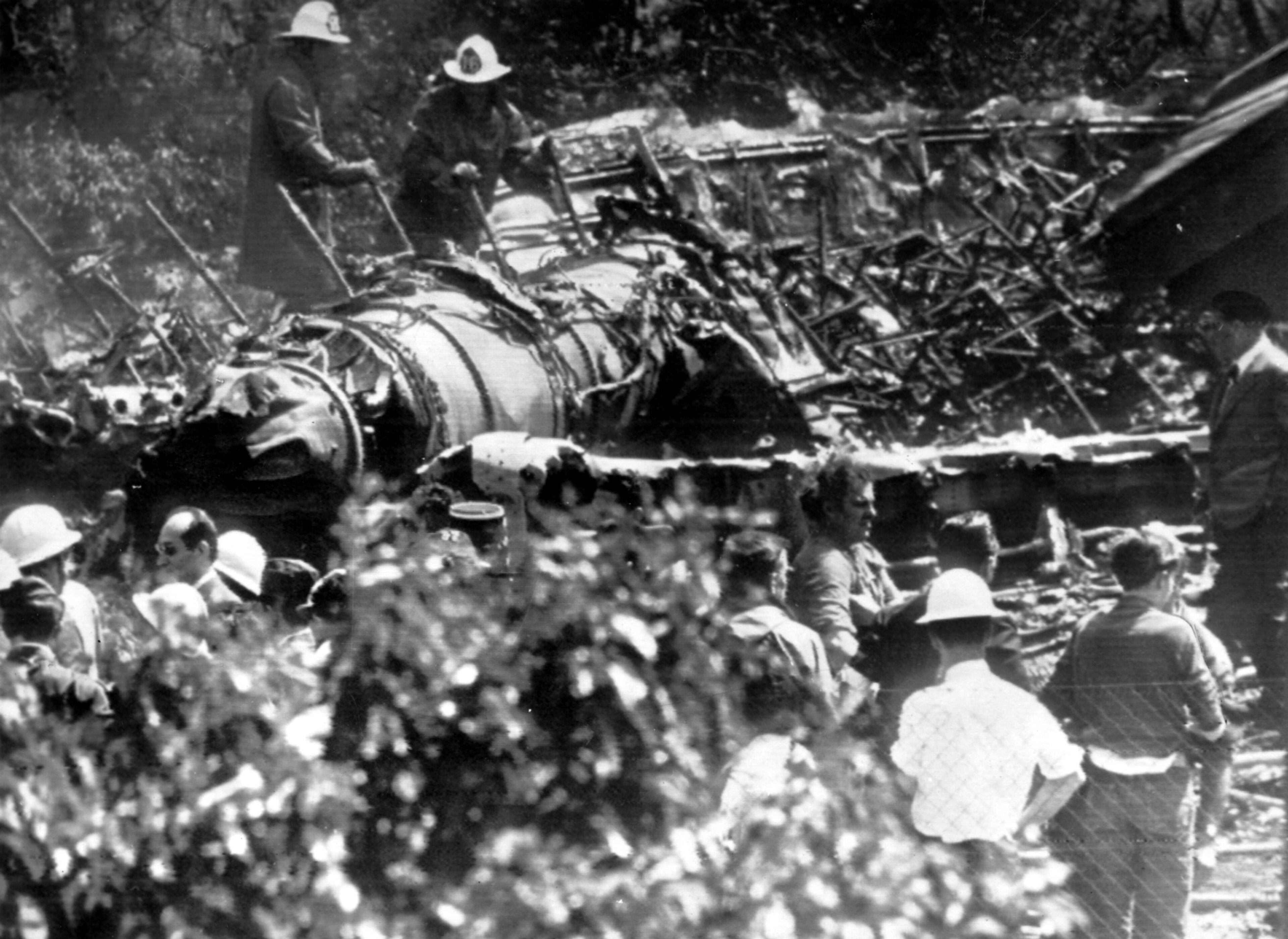 June, 1962 - After flames extinguished, two firemen climb over one of jet engines. Boeing 707 just missed house (extreme right) in Villeneuve Le Roi, near Orly Airfield.