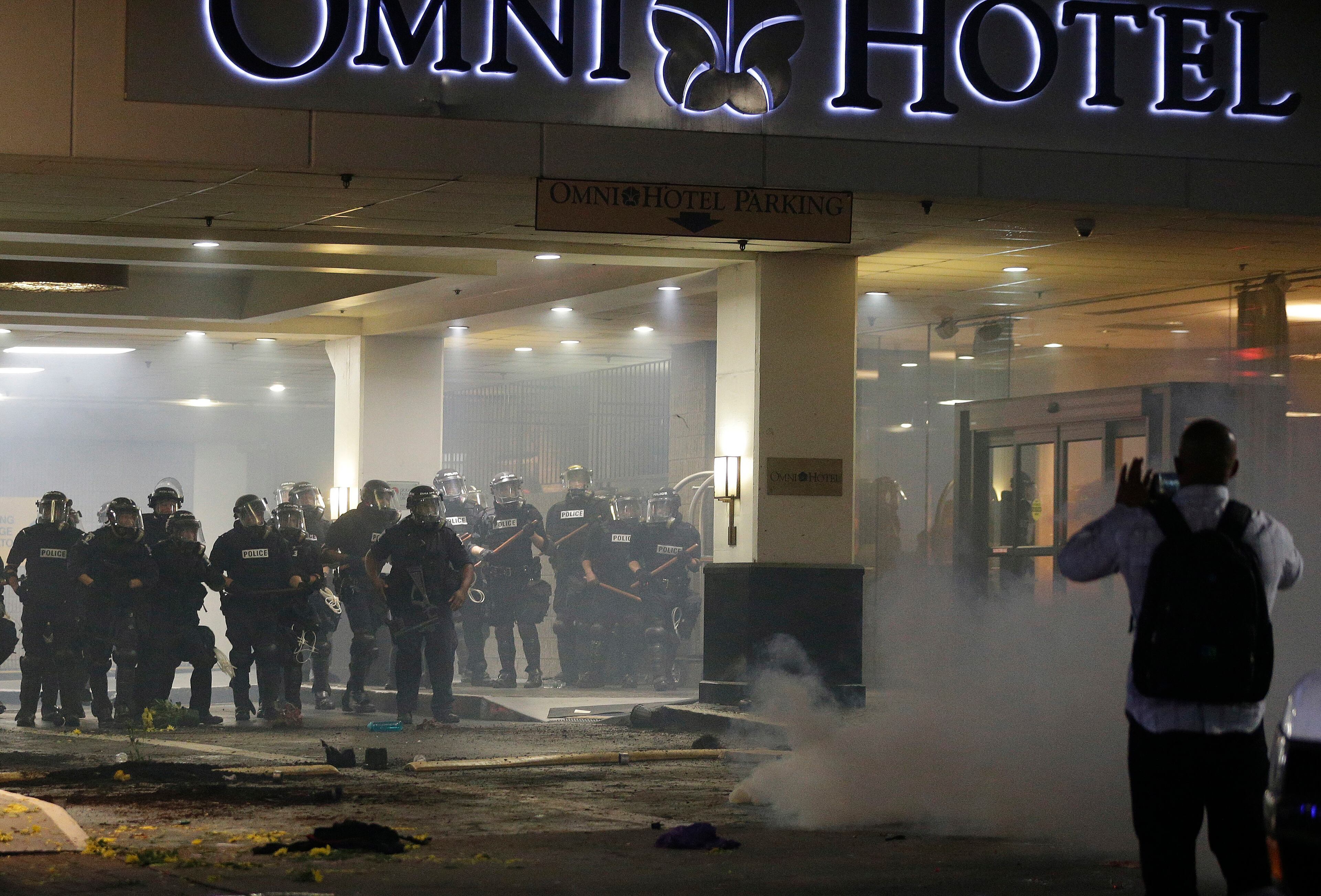 Demonstrators protest Tuesday's fatal police shooting of Keith Lamont Scott in Charlotte, N.C., on Wednesday, Sept. 21, 2016. Protesters have rushed police in riot gear at a downtown Charlotte hotel and officers have fired tear gas to disperse the crowd. At least one person was injured in the confrontation, though it wasn't immediately clear how. Firefighters rushed in to pull the man to a waiting ambulance. (AP Photo/Chuck Burton)