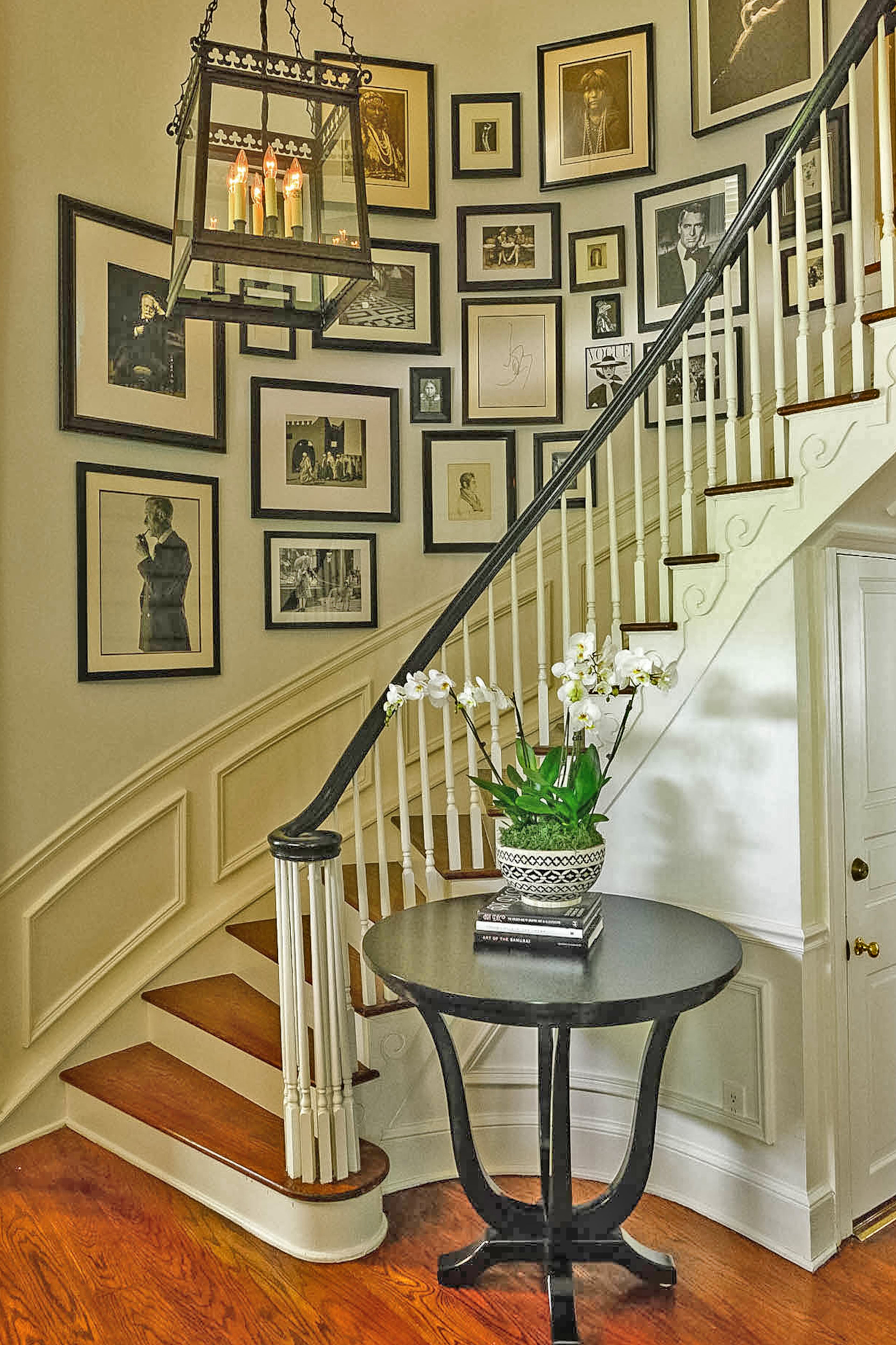 A wall gallery twists up the staircase in the north Atlanta home. The photos have different individuals and subjects, such as actors Clark Gable and Audrey Hepburn, magazine covers and antique photos of Native Americans by Edward Curtis, but the black frames give it a cohesive look.