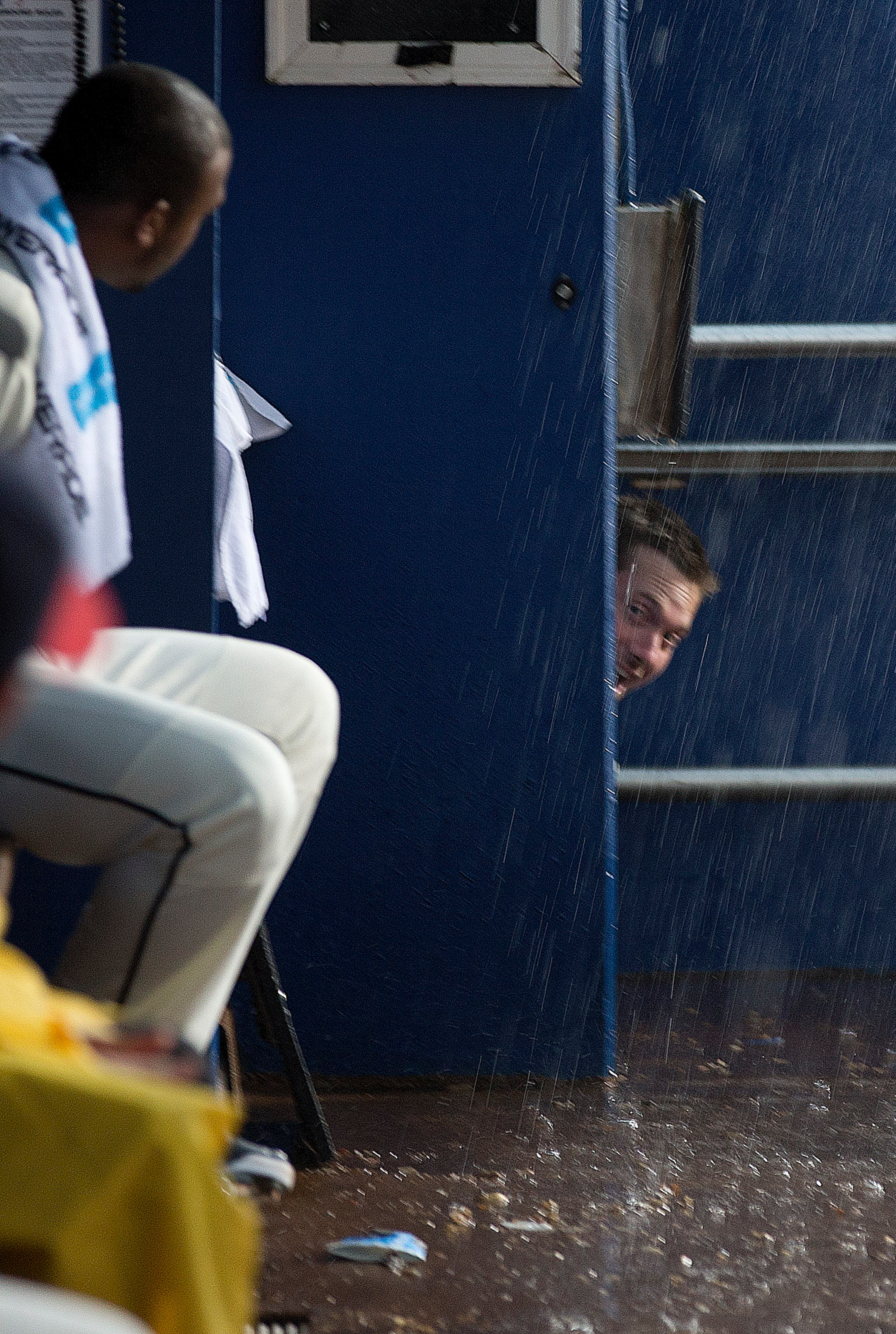 Atlanta Braves third baseman Chris Johnson peers into the dugout during a rain delay before the Braves' baseball game against the Washington Nationals on Saturday, Aug. 9, 2014, in Atlanta. (AP Photo/John Bazemore)