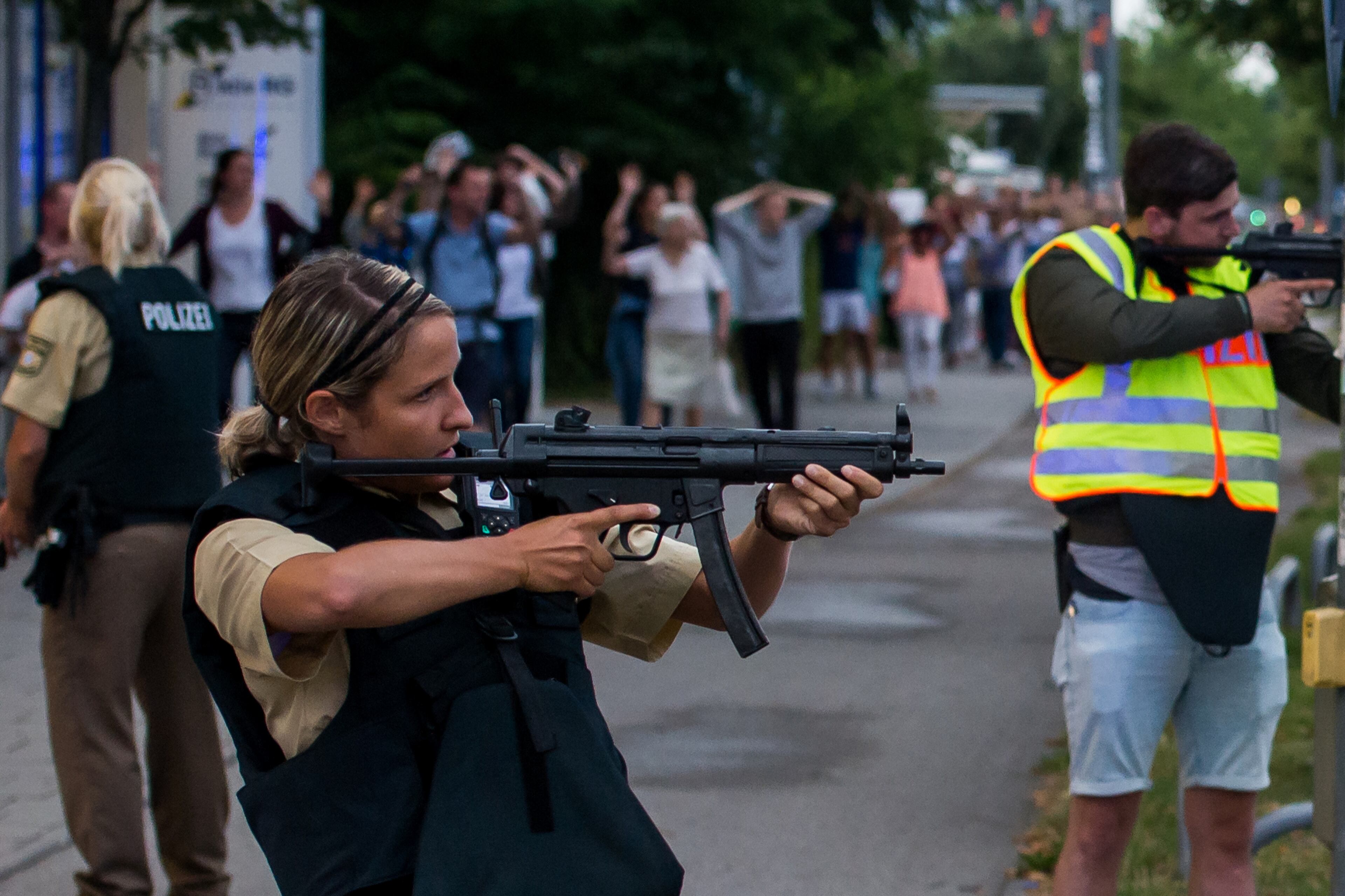 Police officers guard with guns as they escort people near from inside the shopping center as they respond to a shooting at the Olympia Einkaufzentrum (OEZ) at July 22, 2016 in Munich, Germany. According to reports, several people have been killed and an unknown number injured in a shooting at a shopping center in the north-western Moosach district in Munich. Police are hunting the attacker or attackers who are thought to be still at large. (Photo by Joerg Koch/Getty Images)