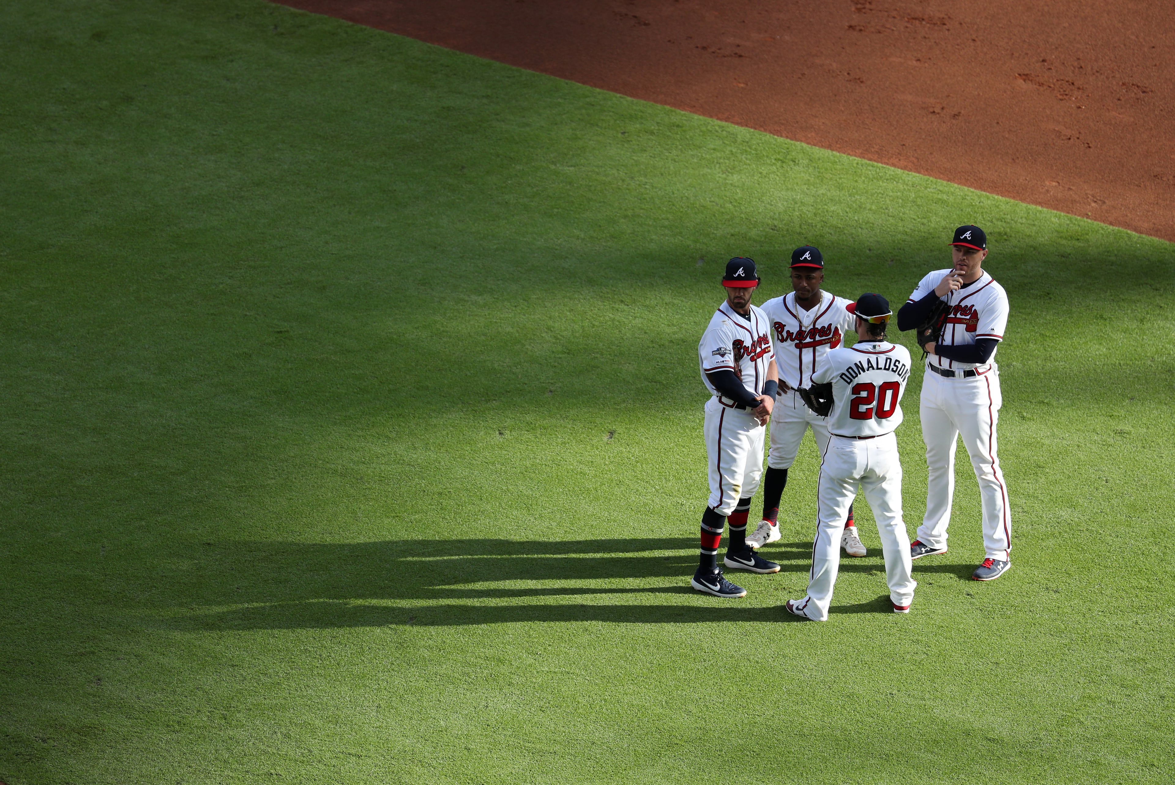 Braves infielders watch during a pitching change in the first inning. (JASON GETZ/SPECIAL TO THE AJC)
