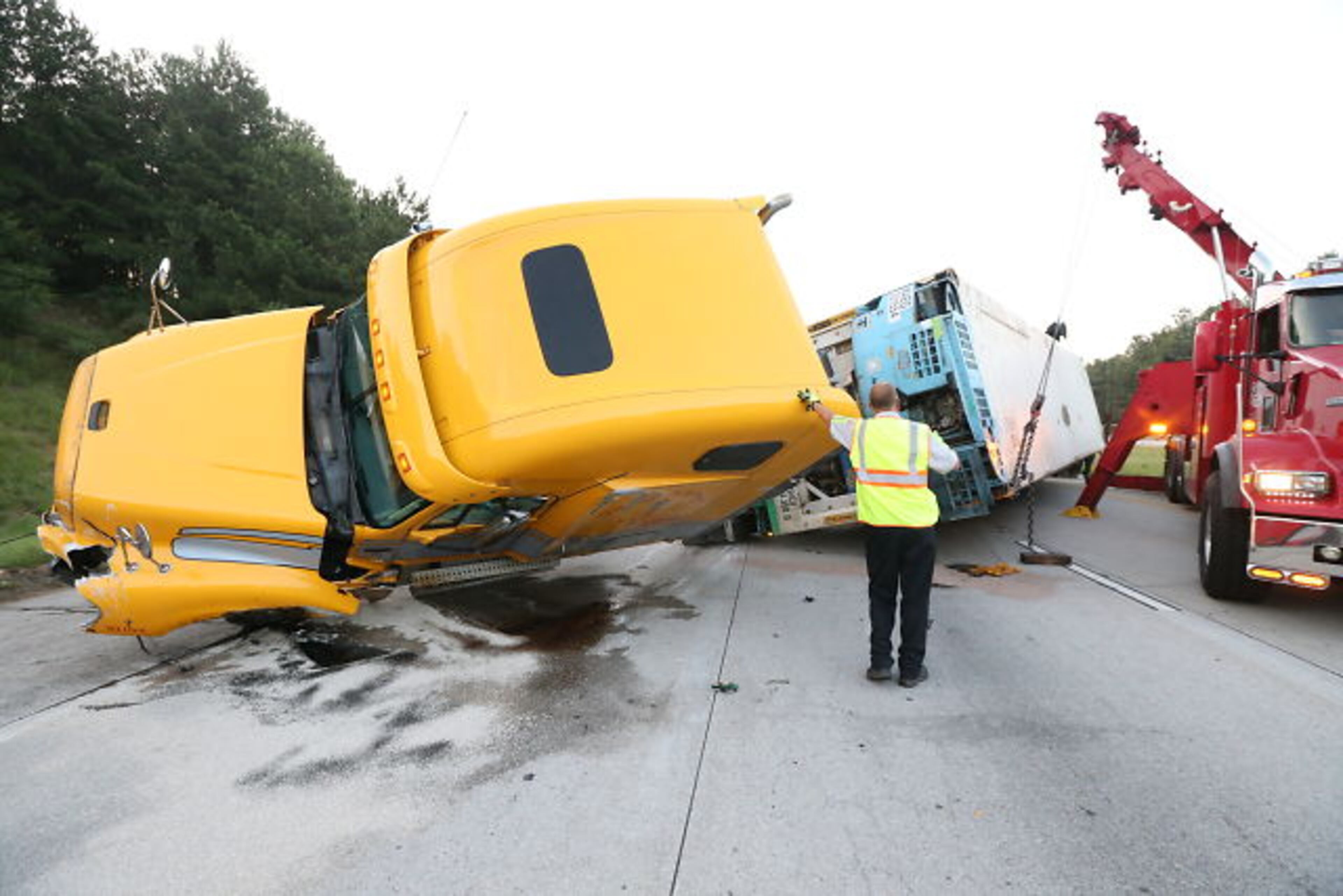 An overturned tractor-trailer shut down I-675 northbound in Clayton County during the early stages of the June 19 morning commute. JOHN SPINK / JSpink@ajc.com