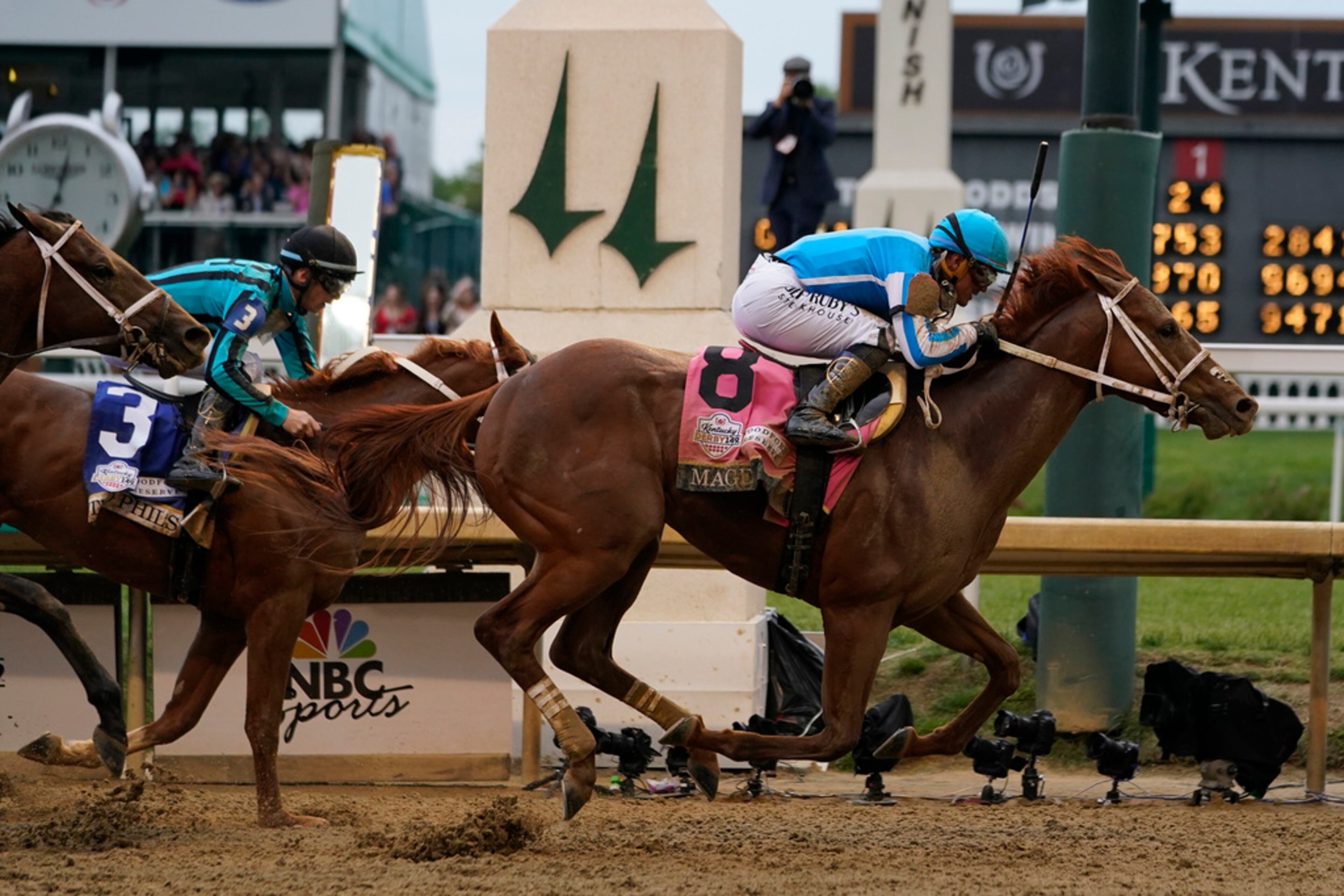 Mage (8), with Javier Castellano aboard, across the finish line to win the 149th running of the Kentucky Derby horse race at Churchill Downs Saturday, May 6, 2023, in Louisville, Ky. (AP Photo/Kiichiro Sato)