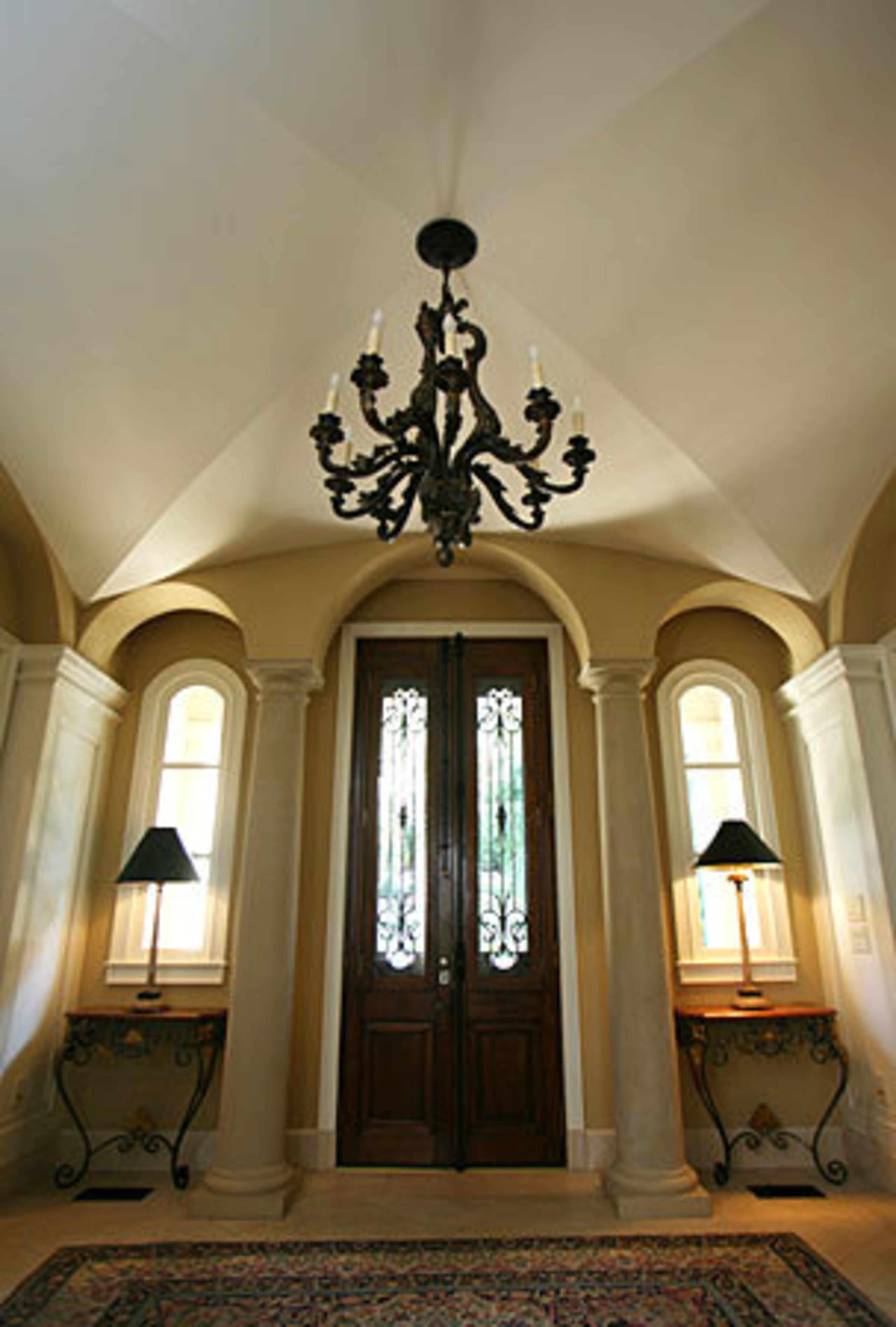 Six years later, the couple rebuilt the house for their growing family, adding some 1,800 square feet of living space and renovating this entrance foyer. They added the groin ceiling, columns and cherry wood floors. The antique front doors date from the 1700s and operate with their original hardware. In fact, even the windows open. The arch motif established here is repeated throughout the Barton home.