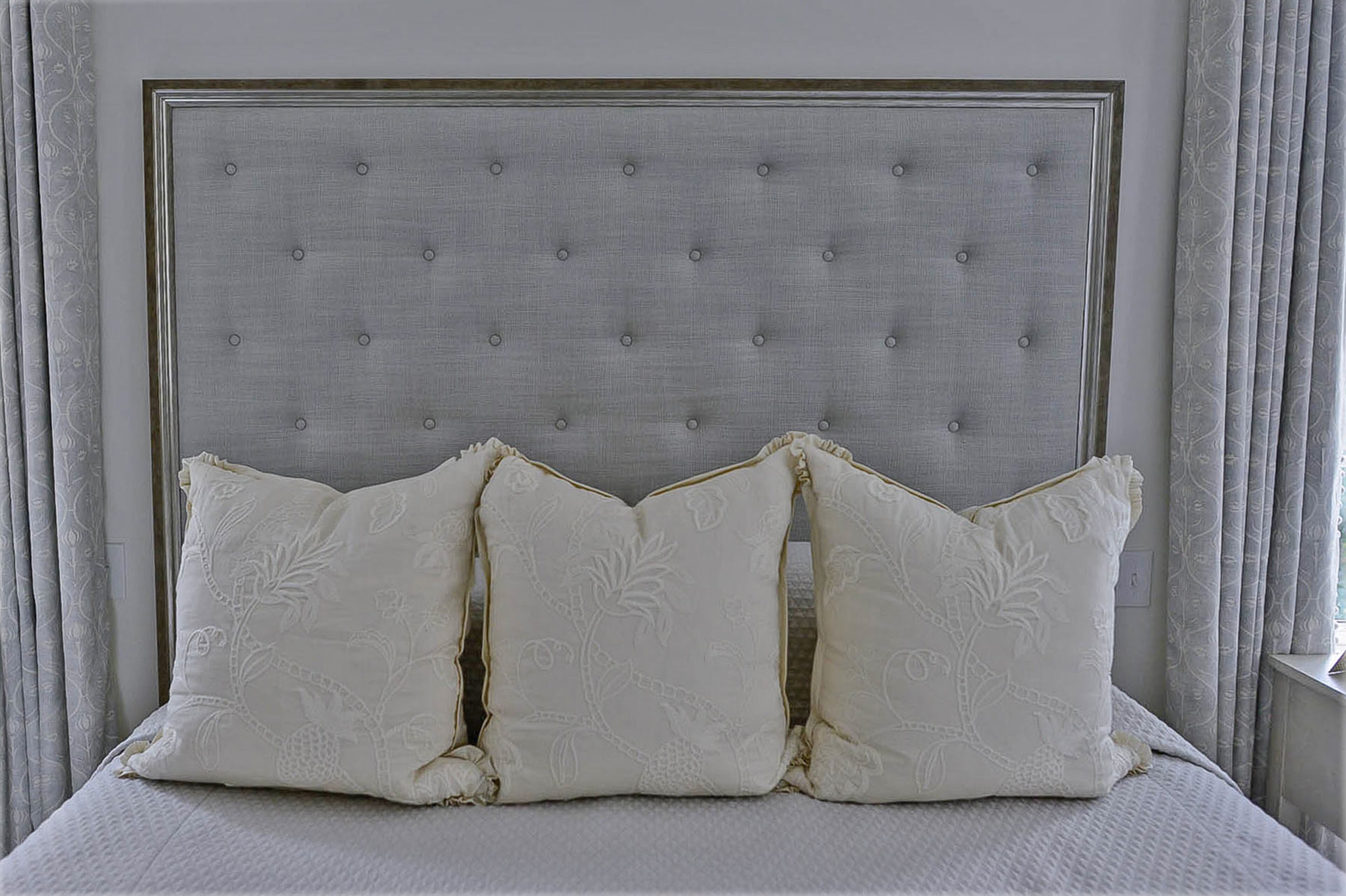 The master bedroom has a soft elements, plus a design hack with the headboard. It's made of picture frame molding and fabric covering plywood that is secured to the wall.