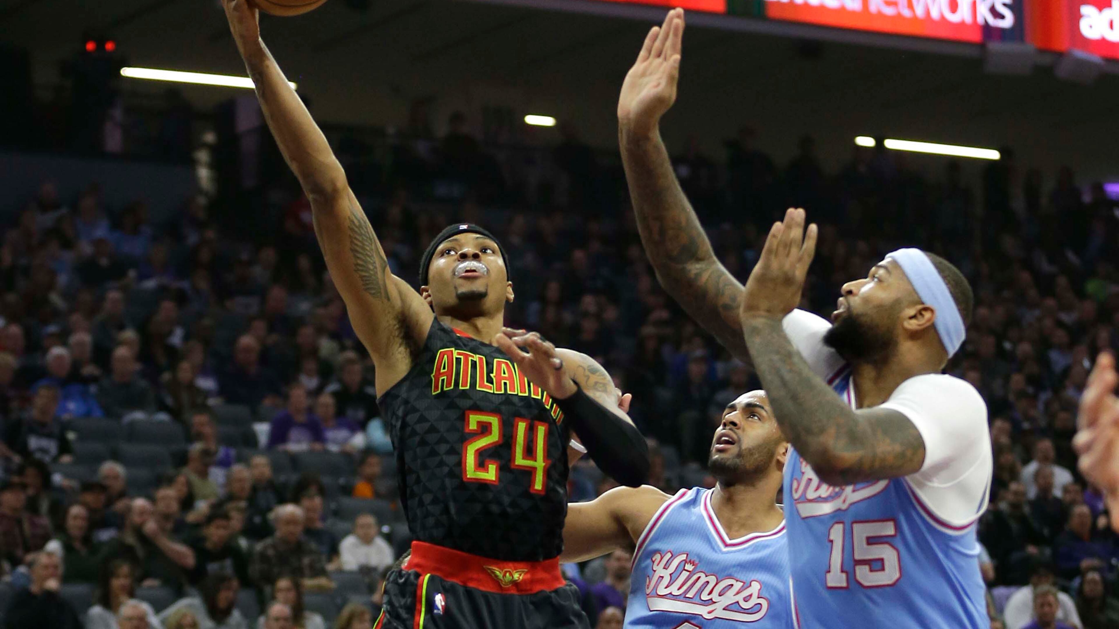 Atlanta Hawks forward Kent Bazemore, left, goes to the basket against Sacramento Kings’ Arron Afflalo, center, and DeMarcus Cousins during the first quarter of an NBA basketball game Friday, Feb. 10, 2017, in Sacramento, Calif. (AP Photo/Rich Pedroncelli)