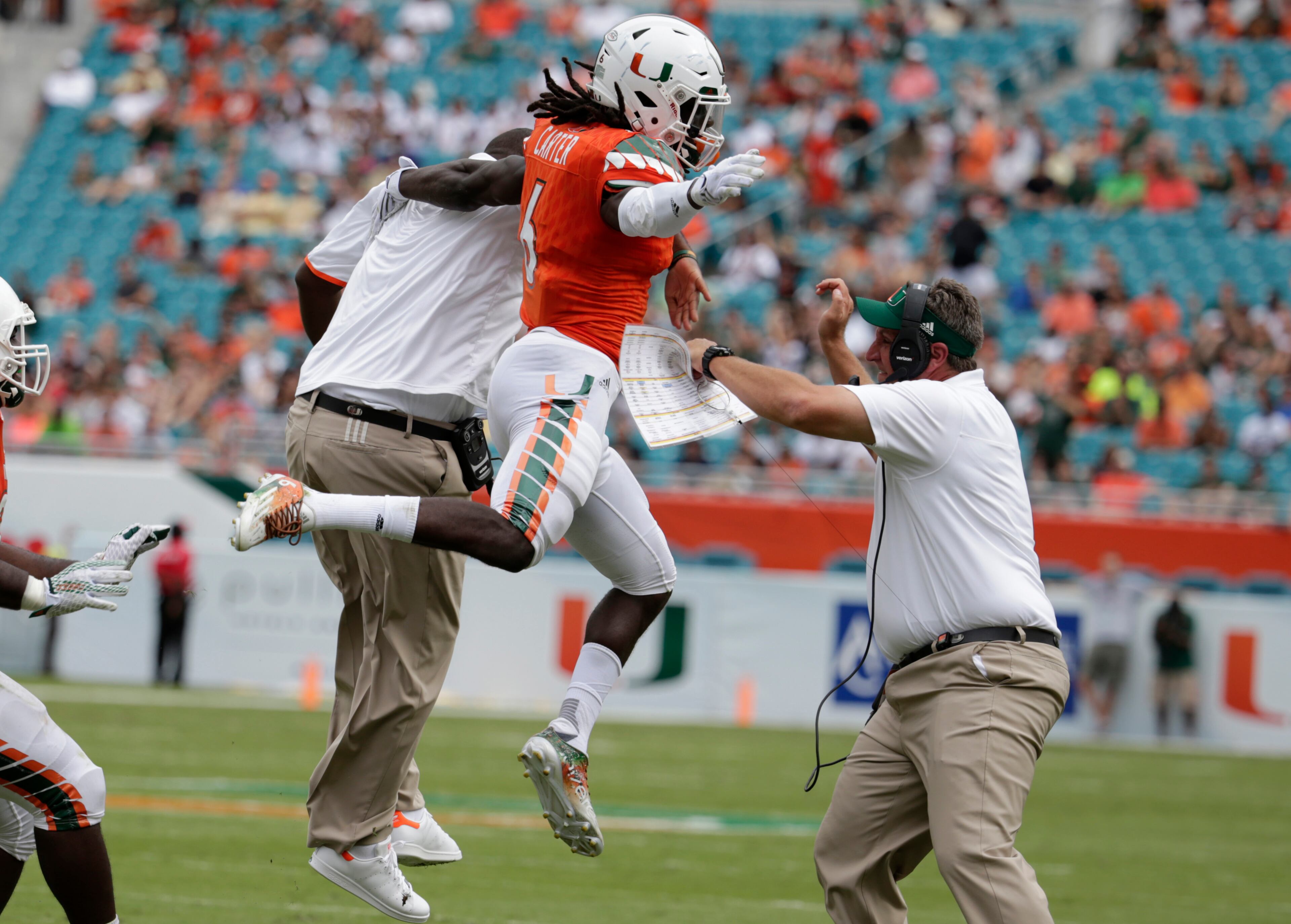 Miami defensive back Jamal Carter (6) celebrates with his coaches after recovering a fumble by Georgia Tech quarterback Matthew Jordan during the first half of an NCAA college football game, Saturday, Nov. 21, 2015 in Miami Gardens, Fla. (AP Photo/Lynne Sladky)