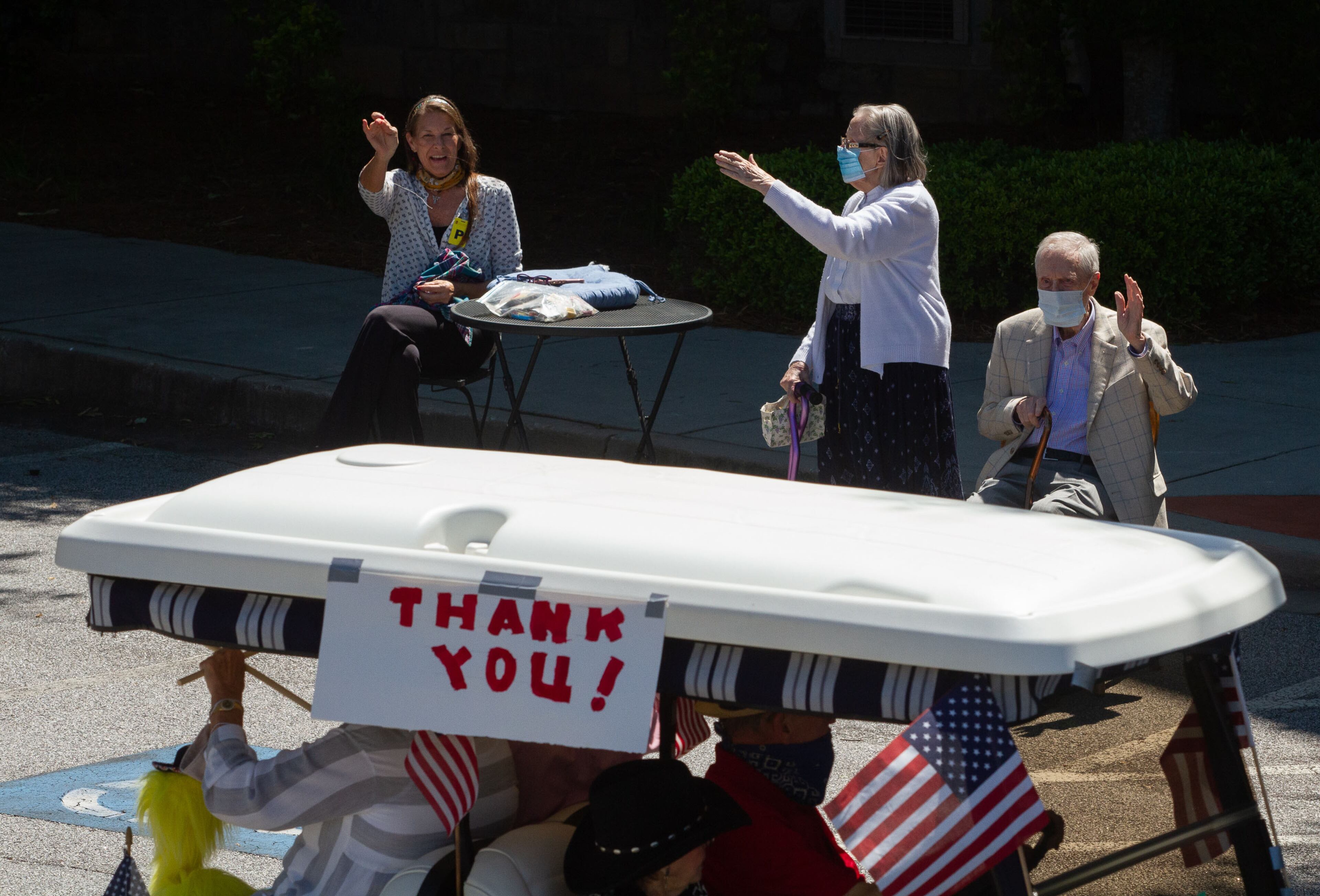 Park Springs independent living residents wave as the golf cart parade rolls by at their Stone Mountain facility May 10, 2020. The parade was organized by the residents to thank all the staff that has voluntarily remain on campus since March 30. STEVE SCHAEFER / SPECIAL TO THE AJC