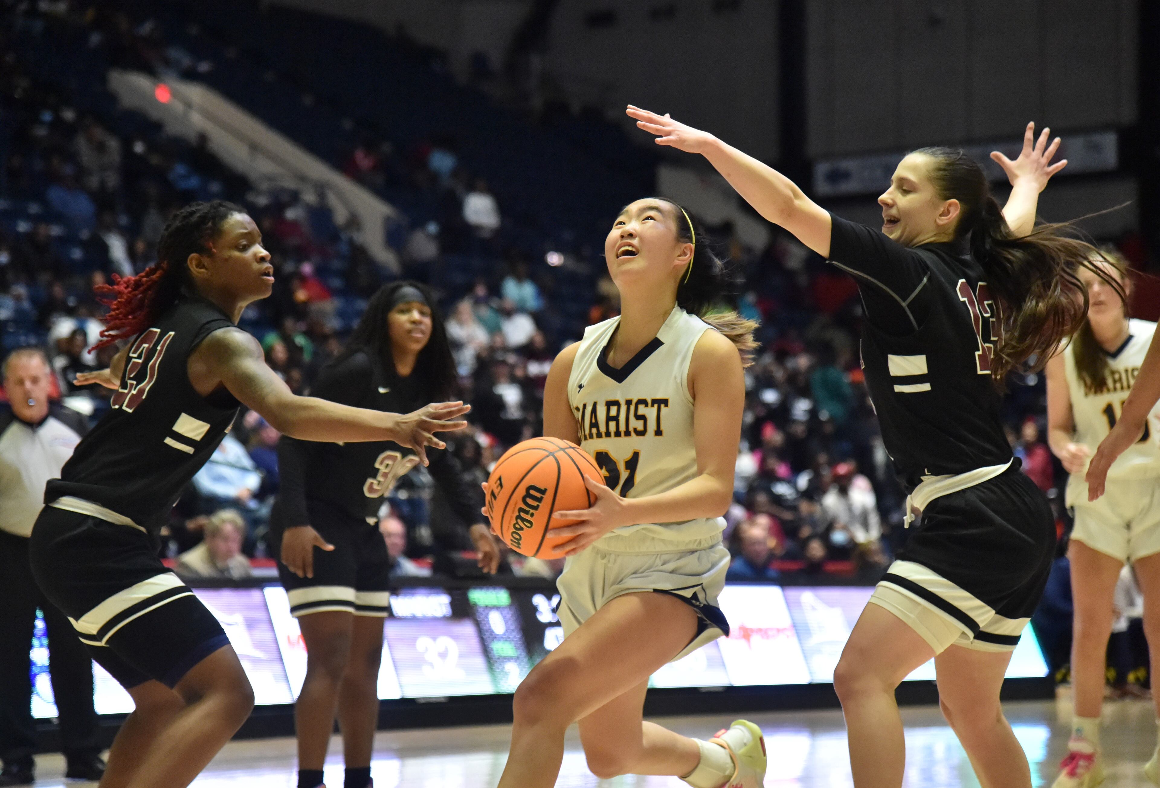 March 9, 2022 Macon - Marist's Lauren Kim (21) drives between Luella's Trinity Layton (21) and Luella's Evangelia Davlakou (13) in the second half of the 2022 GHSA State Basketball Championship game at the Macon Centreplex in Macon on Wednesday, March 9, 2022. Marist won 56-54 over Luella in overtime. (Hyosub Shin / Hyosub.Shin@ajc.com)