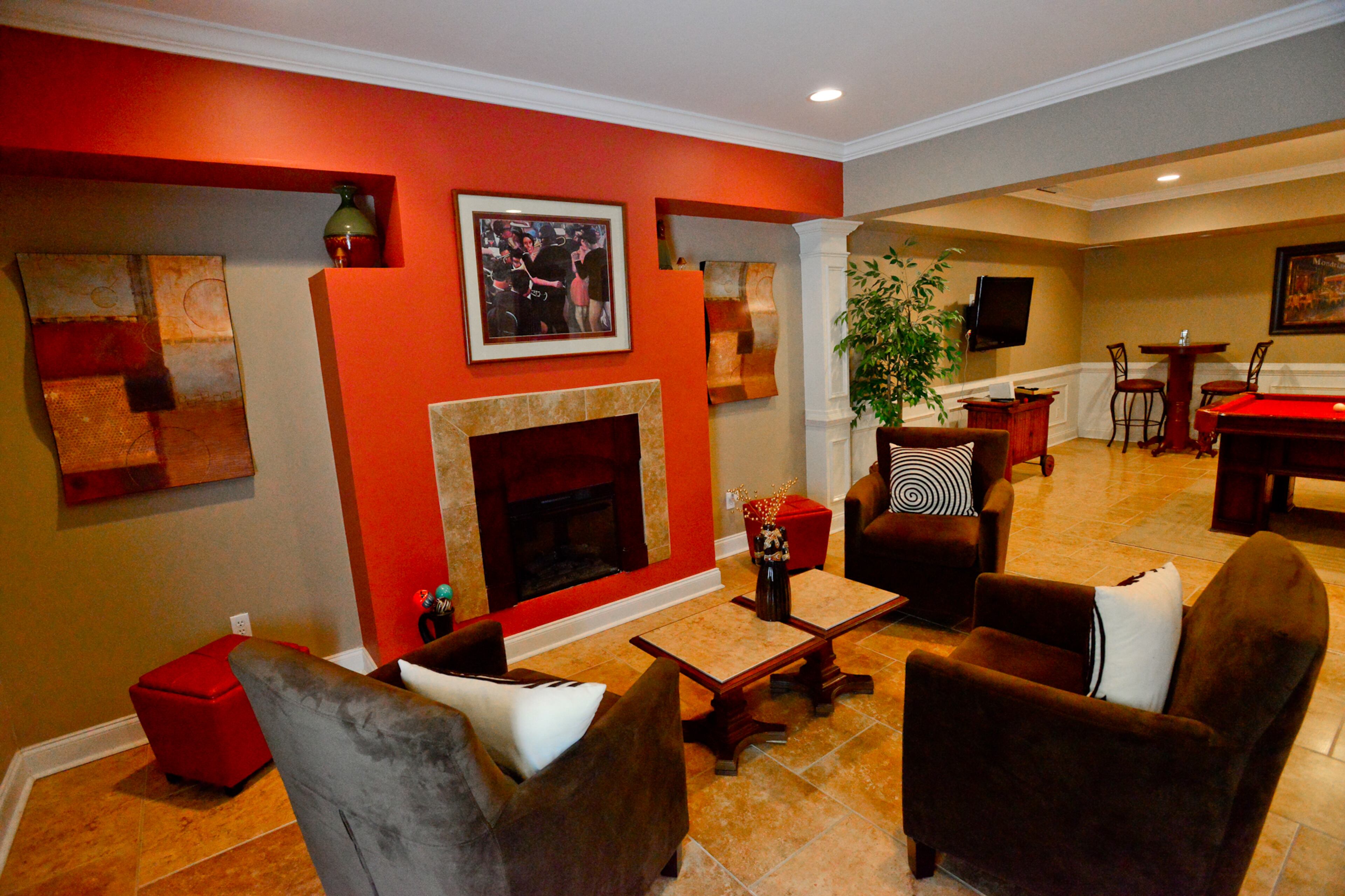 An electric fireplace provides a focal point for a seating area that includes wall art from Garden Ridge and a painting that homeowner Frances Pace bought at a private show several years ago. The chairs on the tile floors are from American Signature Furniture.