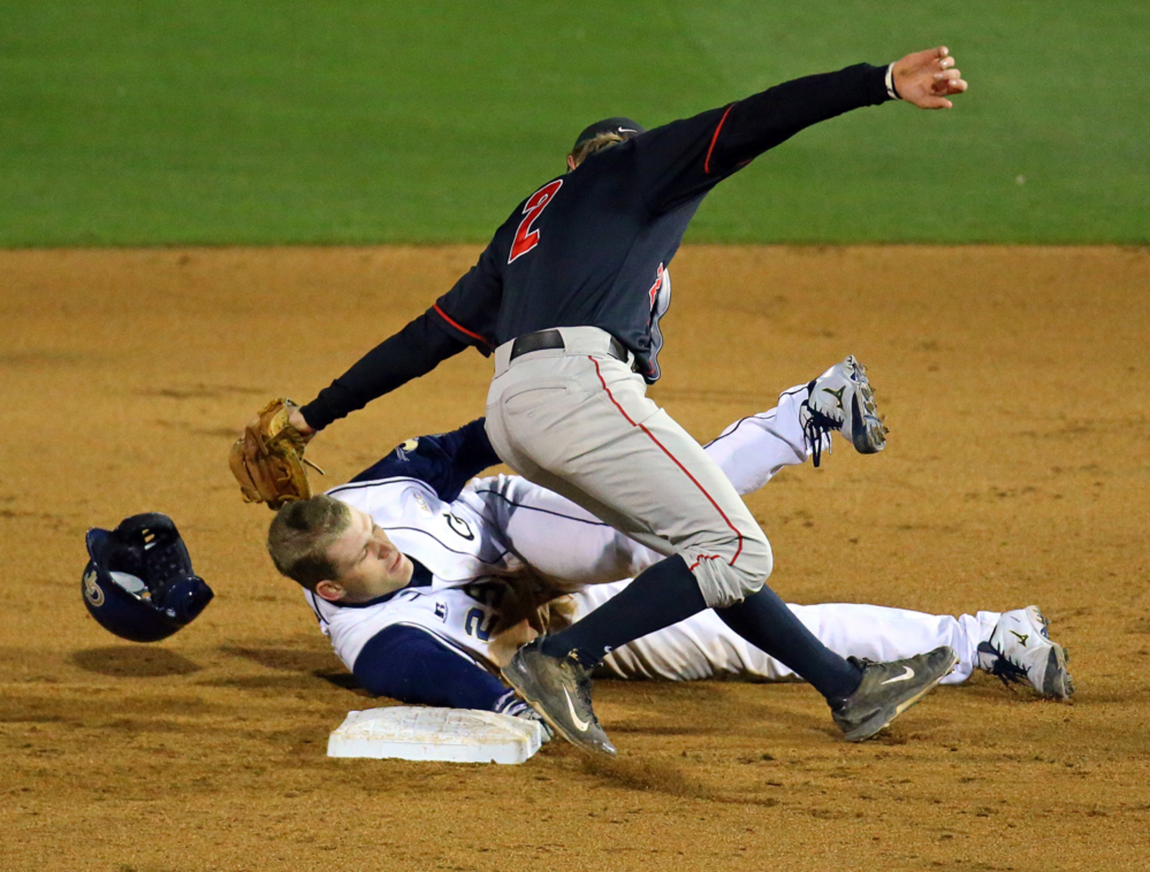 TECH V GEORGIA BASEBALL--041514 ATLANTA: Georgia Tech base runner Mitch Earnest loses his helmet stealing second base just past the tag of Georgia shortstop Hunter Cole during the sixth inning of their college baseball game on Tuesday, April 15, 2014, in Atlanta. CURTIS COMPTON / CCOMPTON@AJC.COM