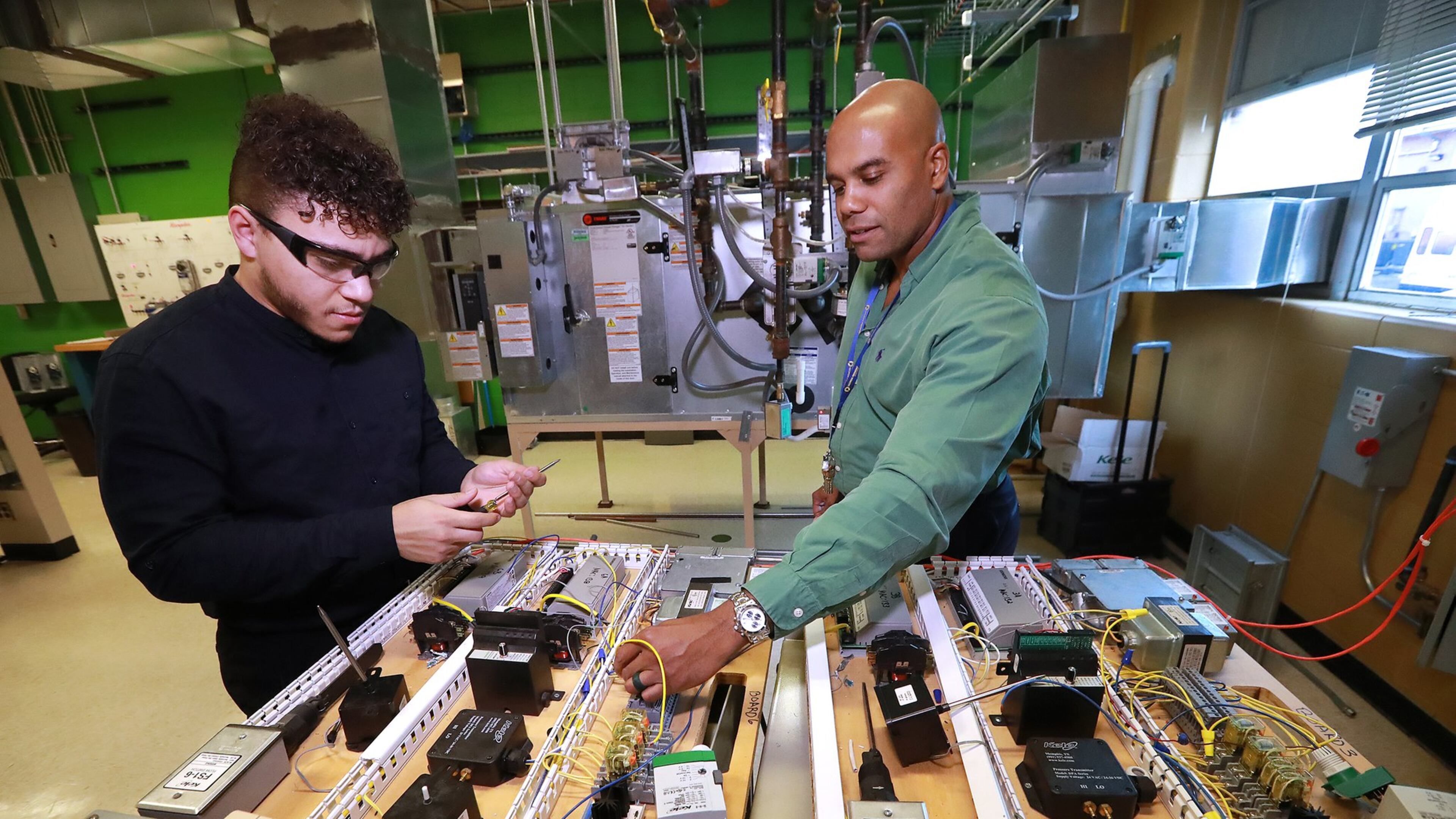 Building automation instructor Robert Croom works with student Adam Lovell on a controller board with input/output devices during a class in the Building Automation Systems program at Georgia Piedmont Technical College on Thursday, Jan. 30, 2020, in Clarkston.CURTIS COMPTON / CCOMPTON@AJC.COM