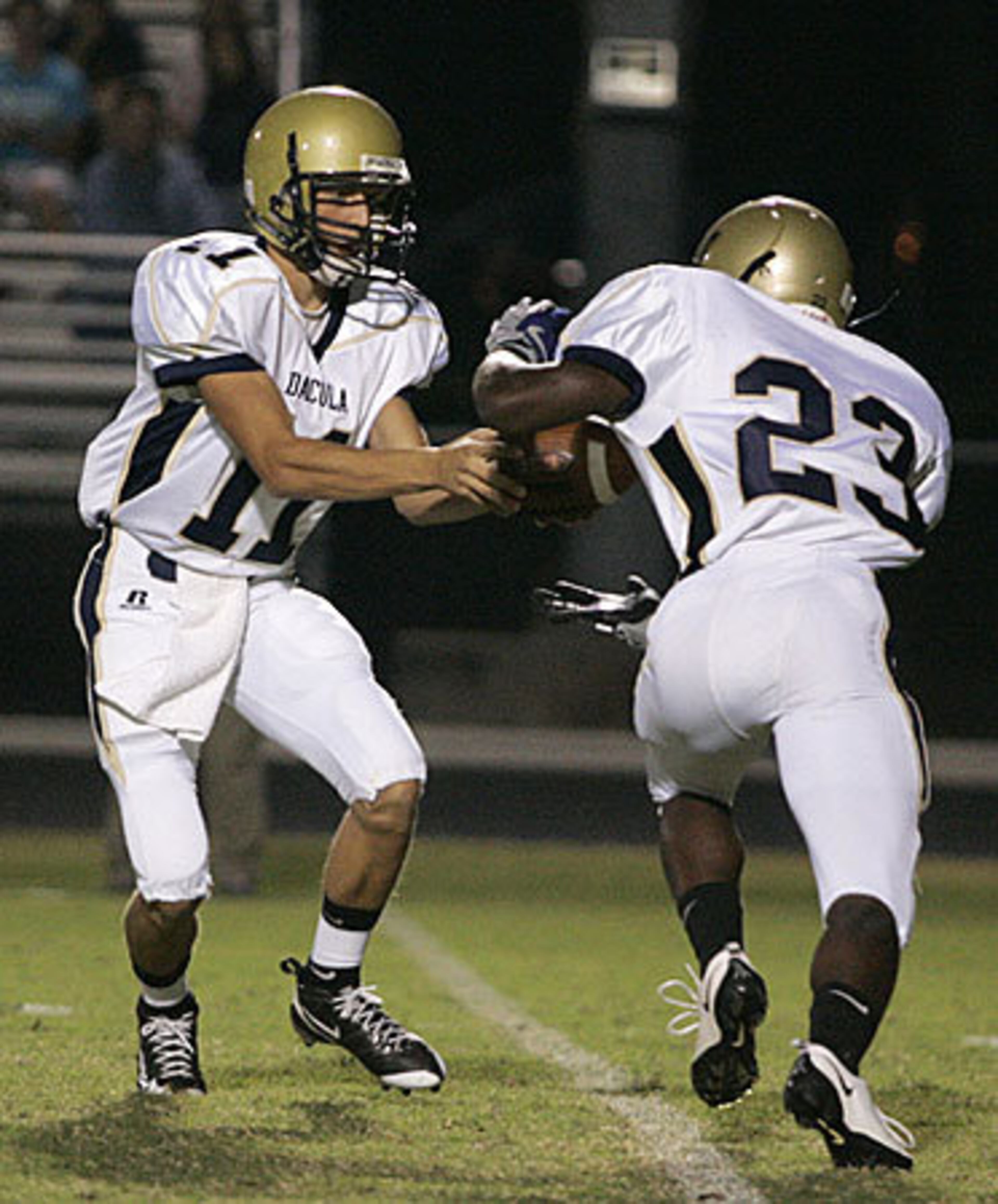 Dacula quarterback Hunter Watts (L). hands off to running back Aashad Holloway.
